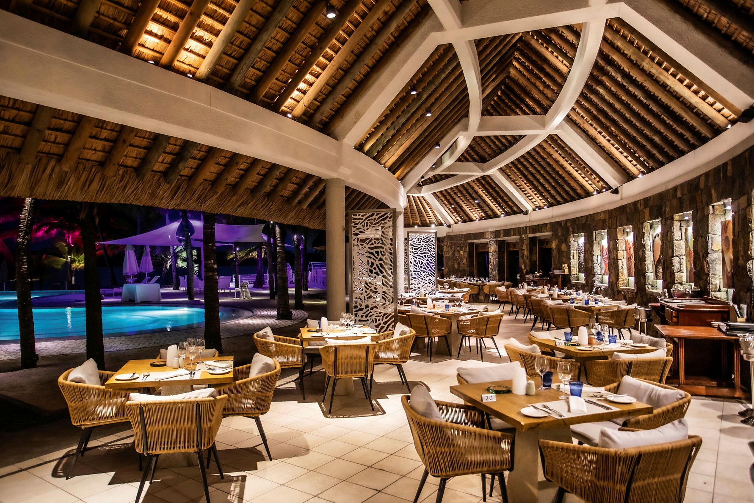 Restaurang med sittplatser och utsikt över en pool utomhus. (AI-genererad text)