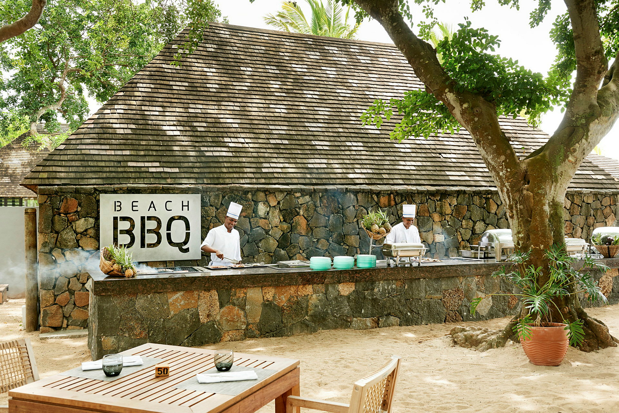 Bild av en utomhusservering med stenbyggnad och BBQ-område. (AI-genererad text)