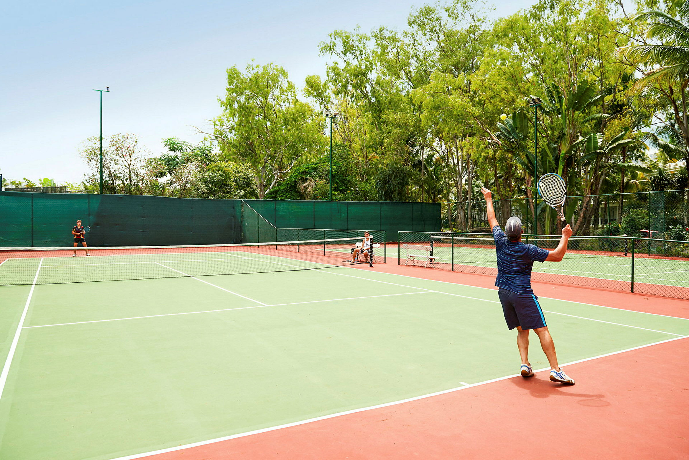 Personer spelar tennis på en utomhusplan. (AI-genererad text)