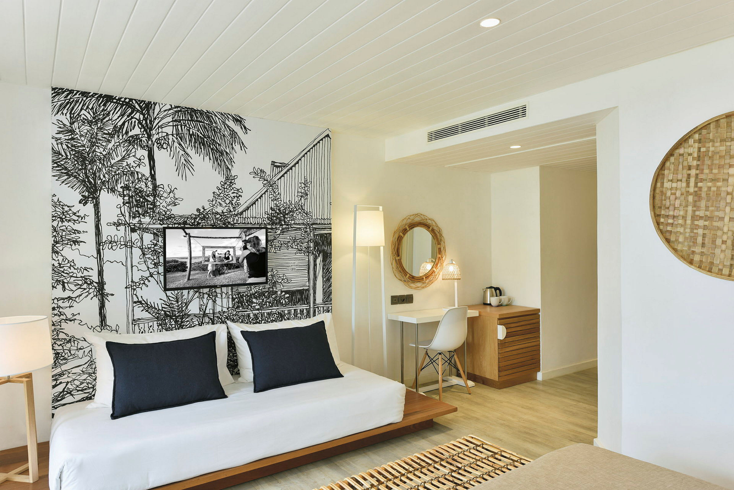 Ett hotellrum med modern inredning, en dekorativ väggmålning och bekväm sittgrupp. (AI-genererad text)