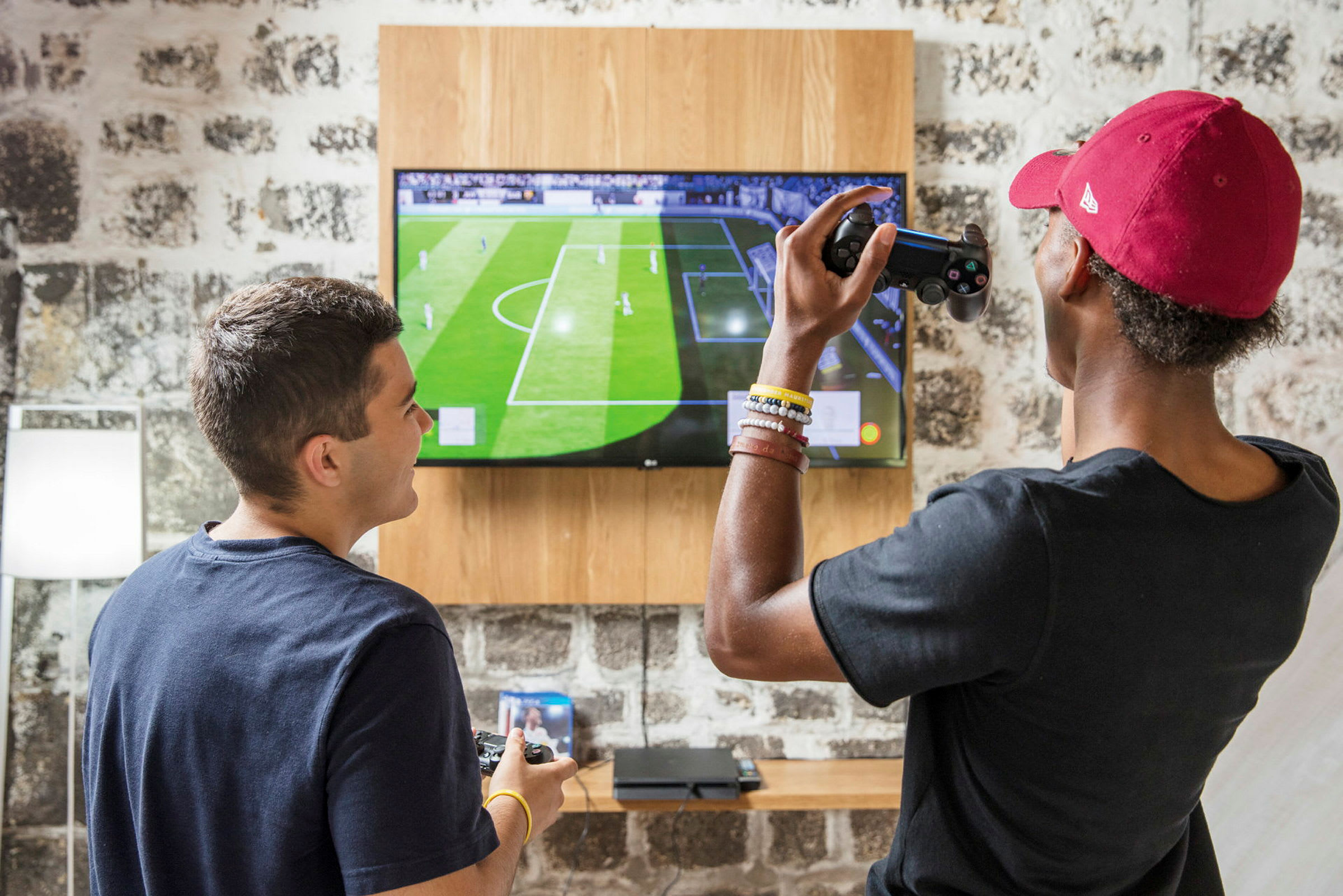 Två personer spelar ett fotbollsspel på en TV-skärm. (AI-genererad text)