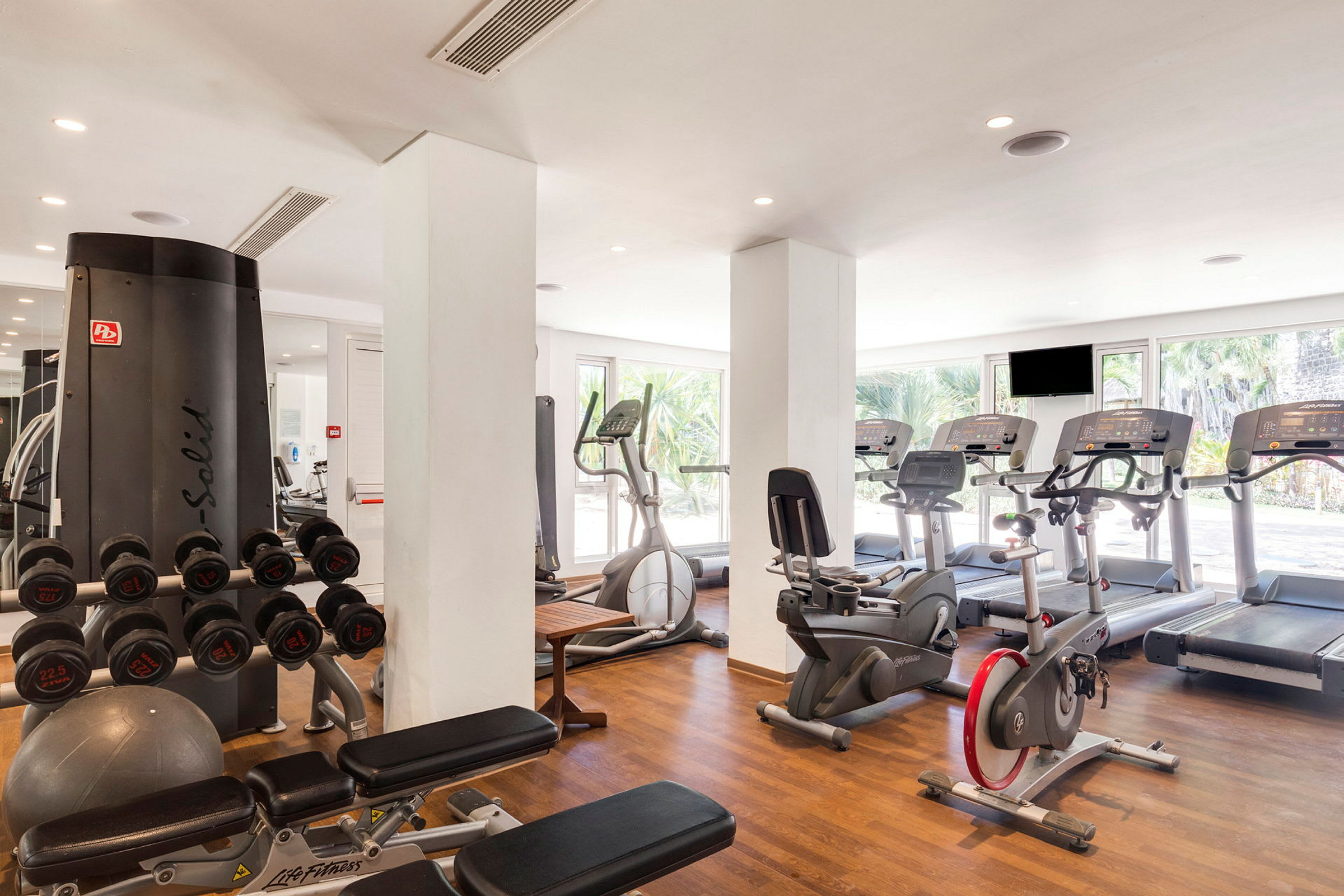 Gym med träningsmaskiner inklusive löpband, cyklar och tyngdlyftningsutrustning. (AI-genererad text)