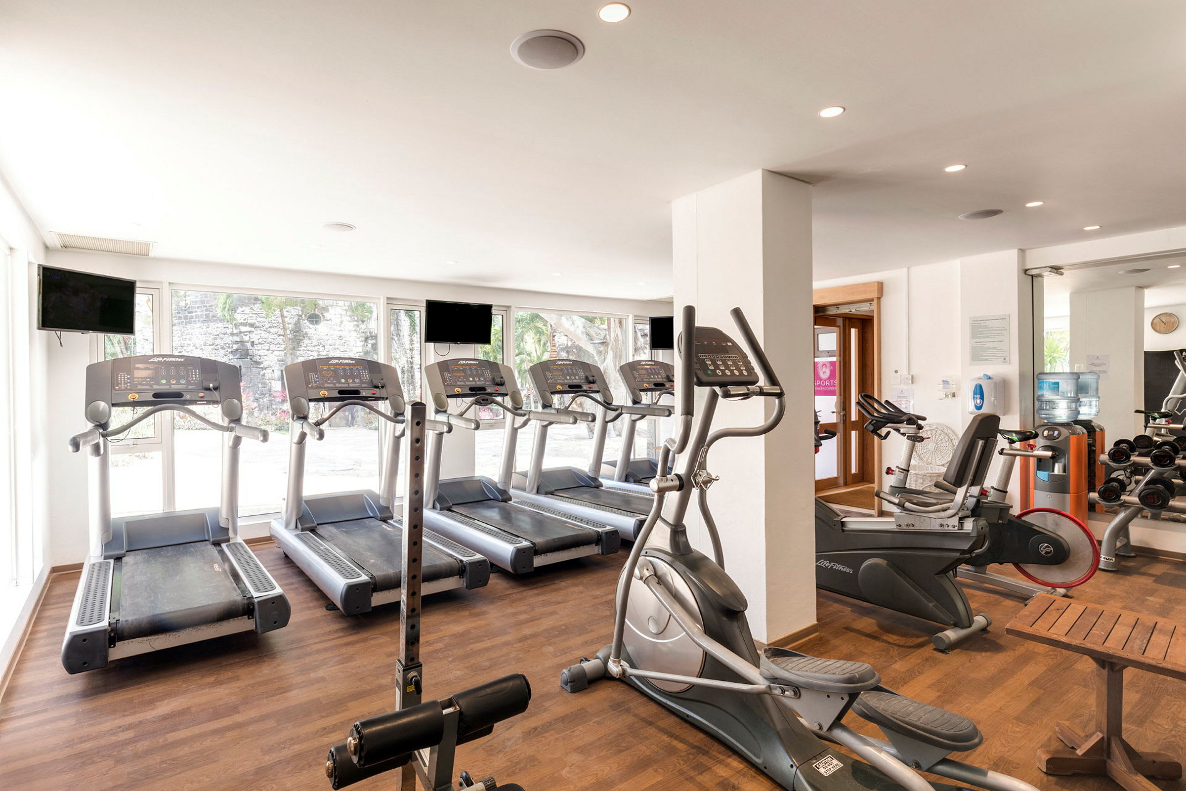 Gym med träningsredskap och maskiner som löpband och motionscyklar. (AI-genererad text)