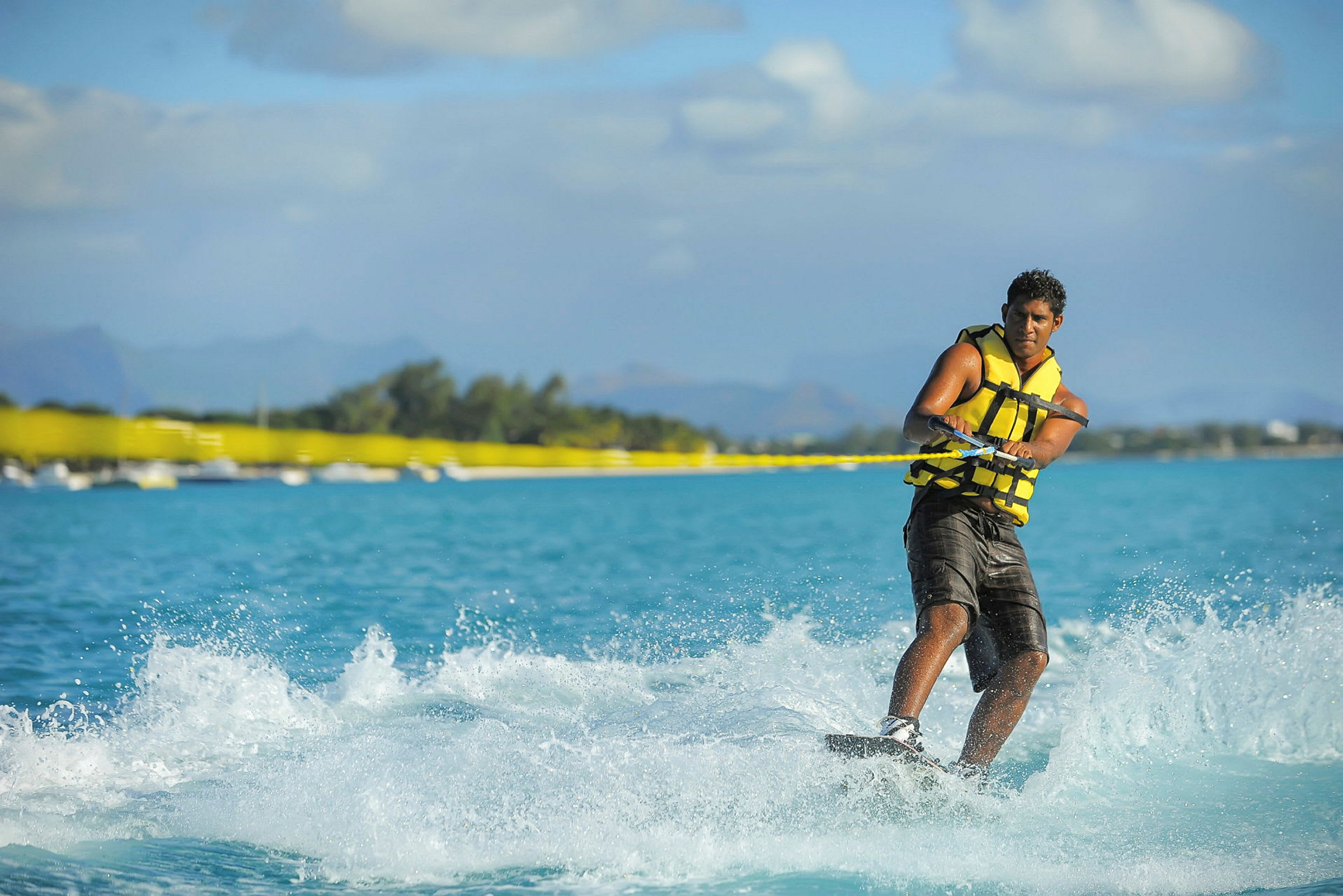 Person wakeboardar på blått vatten, berg i bakgrunden. (AI-genererad text)