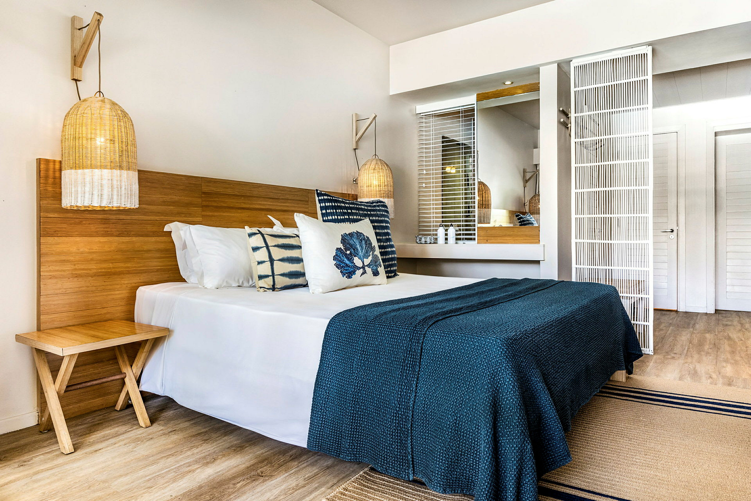 Ett hotellrum med en dubbelsäng, trädetaljer och blå inredning. (AI-genererad text)