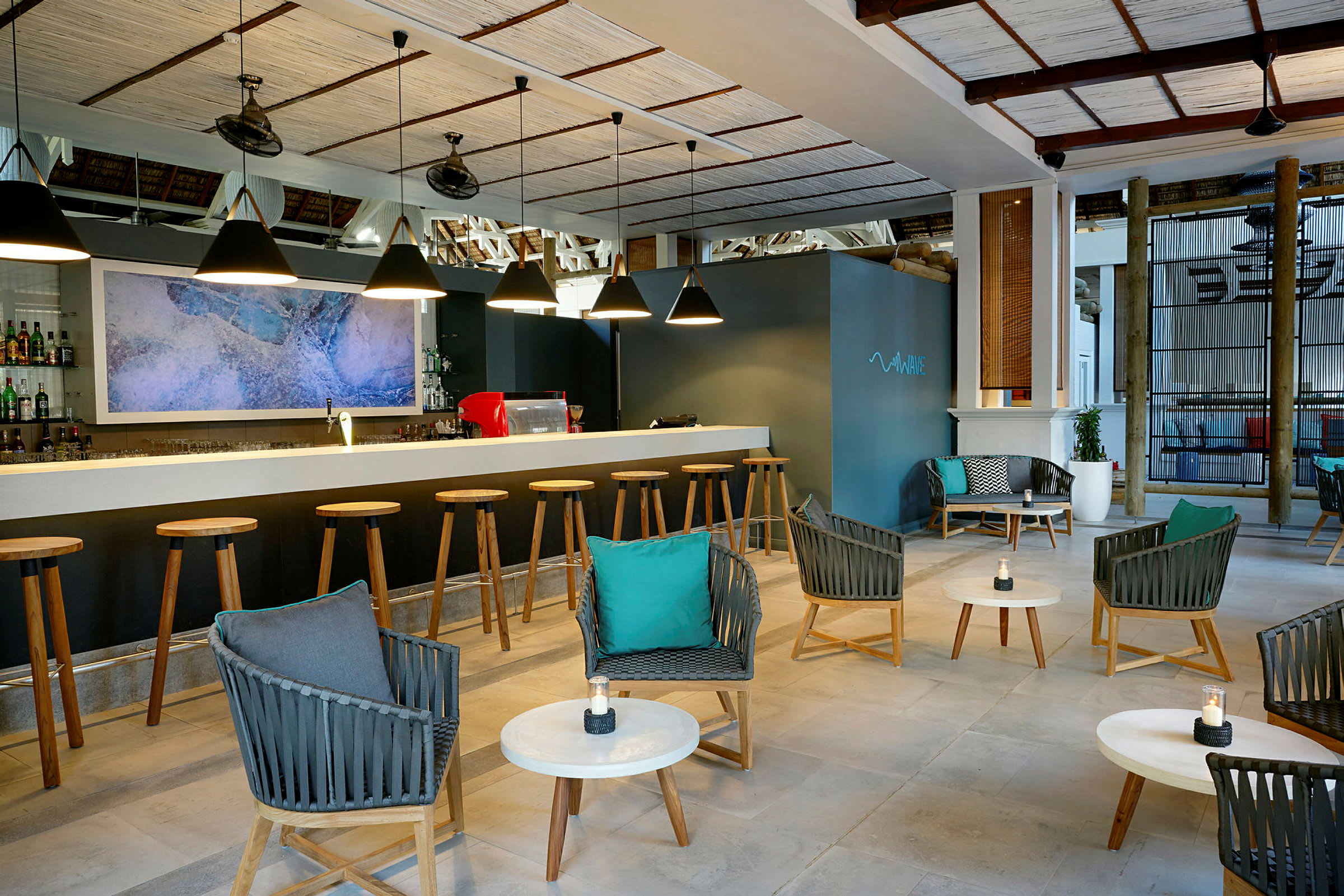 En modern bar med rad av barstolar framför en bardisk, mysig sittgrupp med stolar och bord i förgrunden. (AI-genererad text)