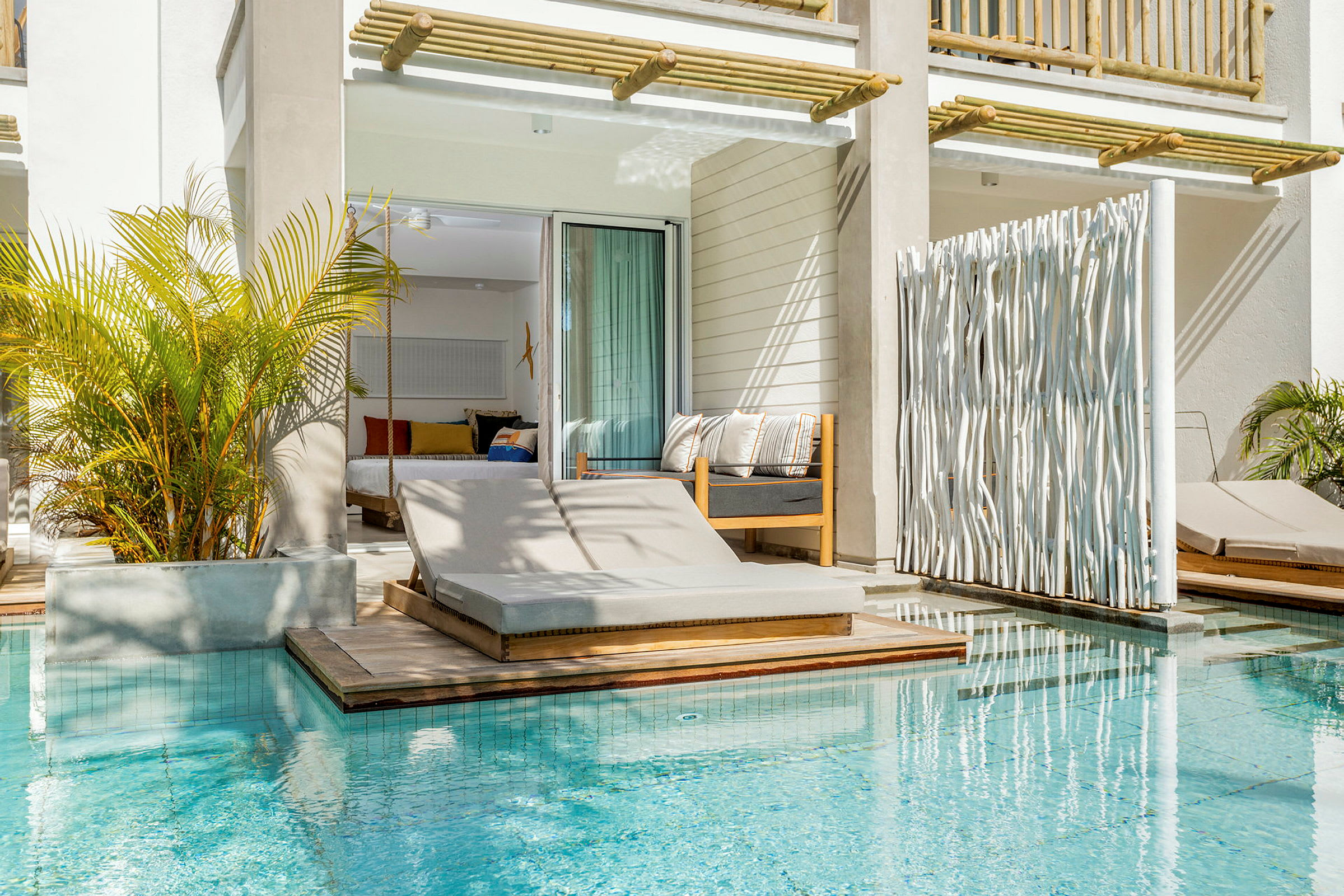 En solstol vid en pool framför ett rum med öppen dörr. (AI-genererad text)