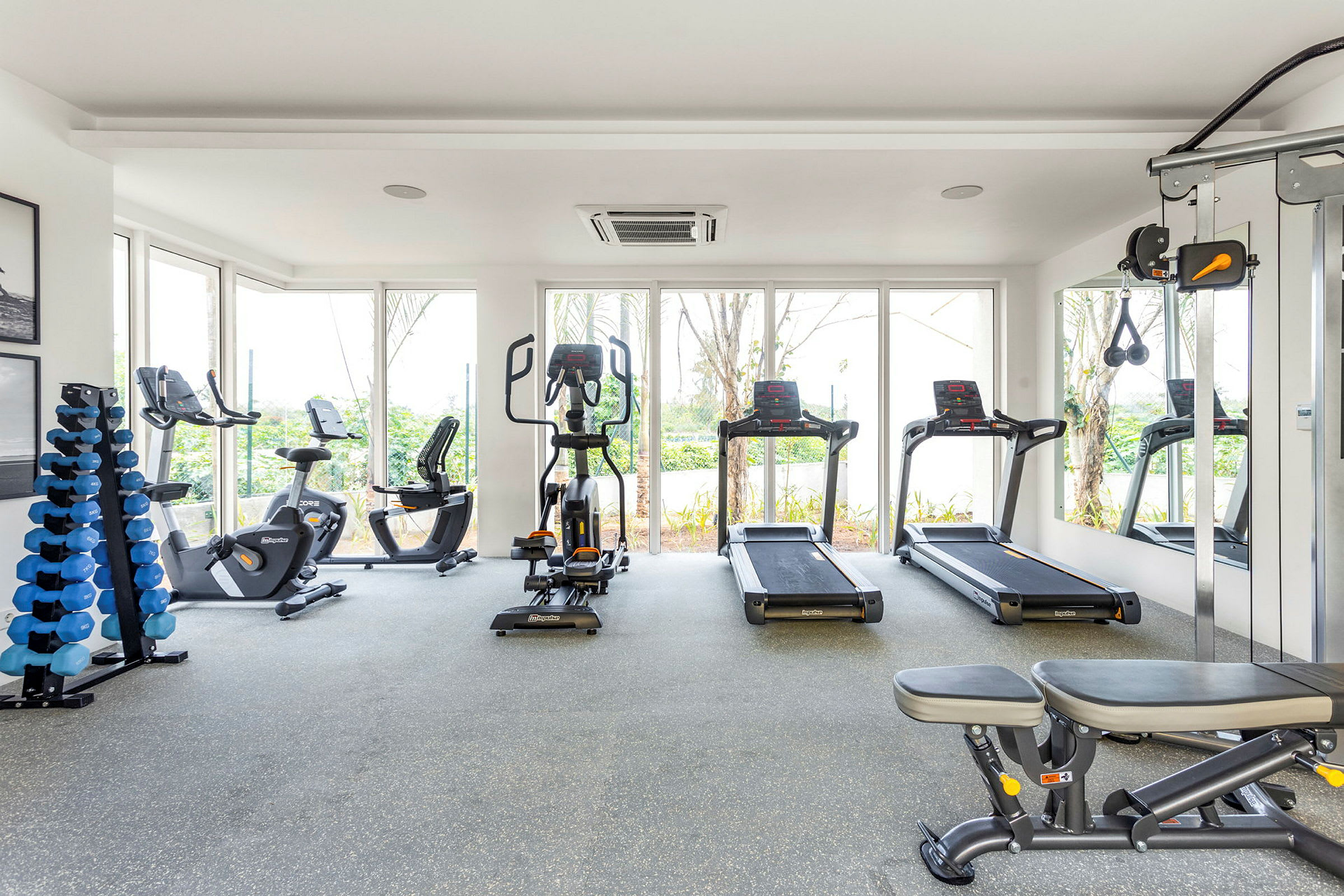 Bild av ett gym med träningsutrustning som löpband, motionscyklar och vikter. (AI-genererad text)