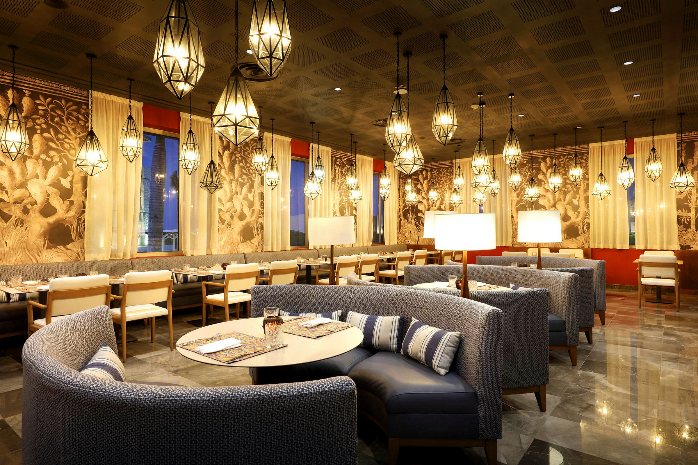 En trevligt inredd restaurang med hängande lampor, polerade golv och fina möbler. (AI-genererad text)