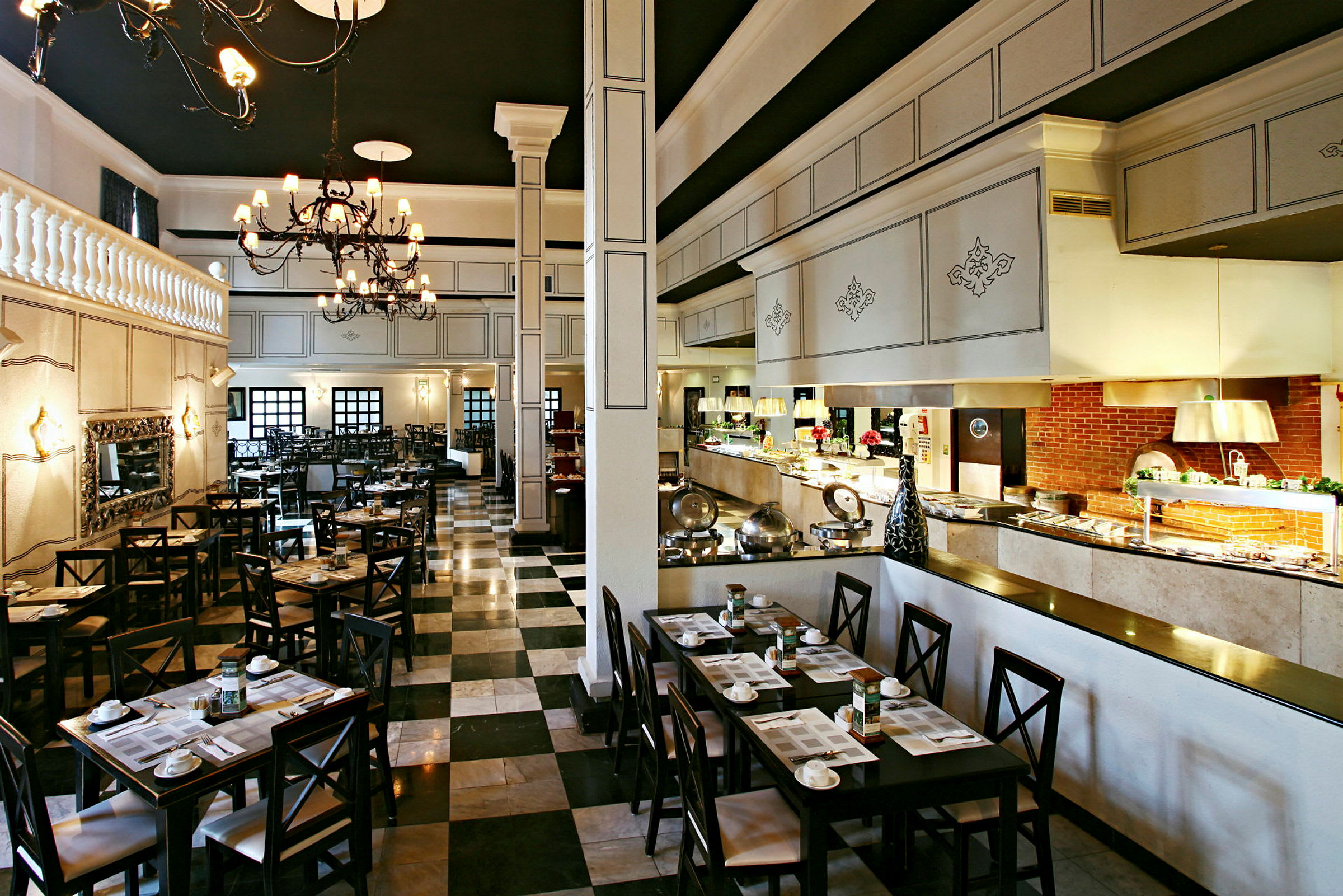 Bild av en elegant restaurang med dukade bord, stora ljuskronor och en buffé längs ena sidan. (AI-genererad text)