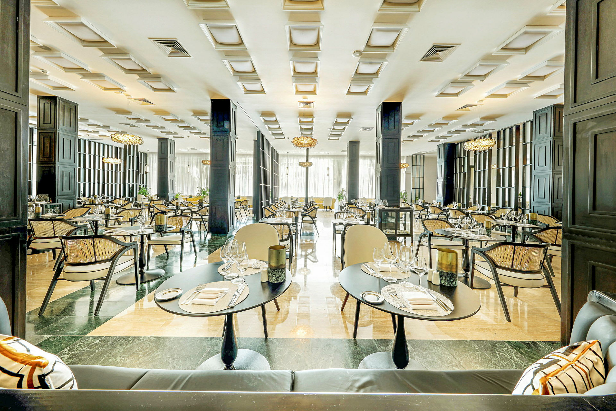 En elegant restaurang med dukade bord, stolar och modern inredning. (AI-genererad text)