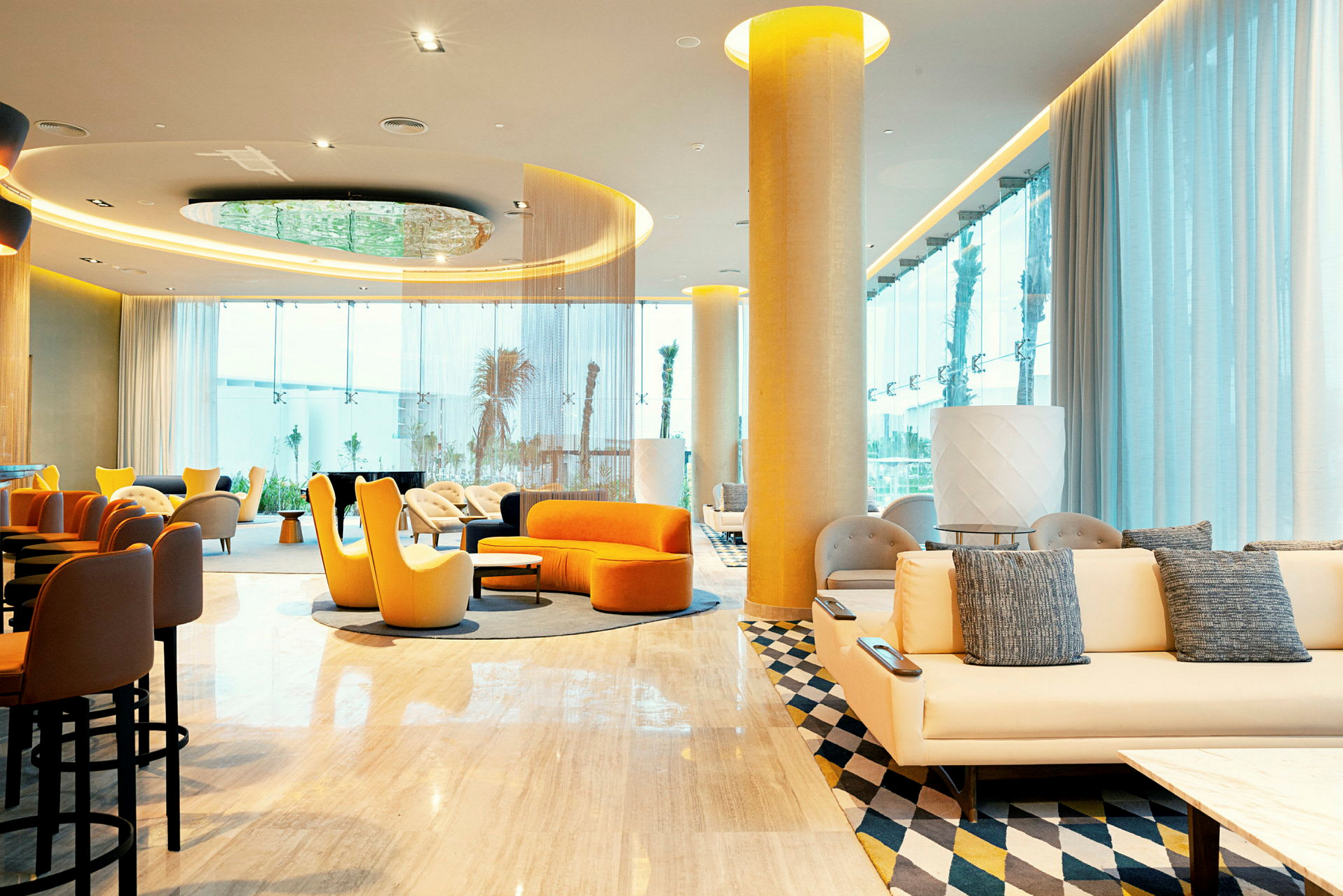 Interiör av ett modernt hotellobbyområde med färgglada sittmöbler och stora fönster. (AI-genererad text)
