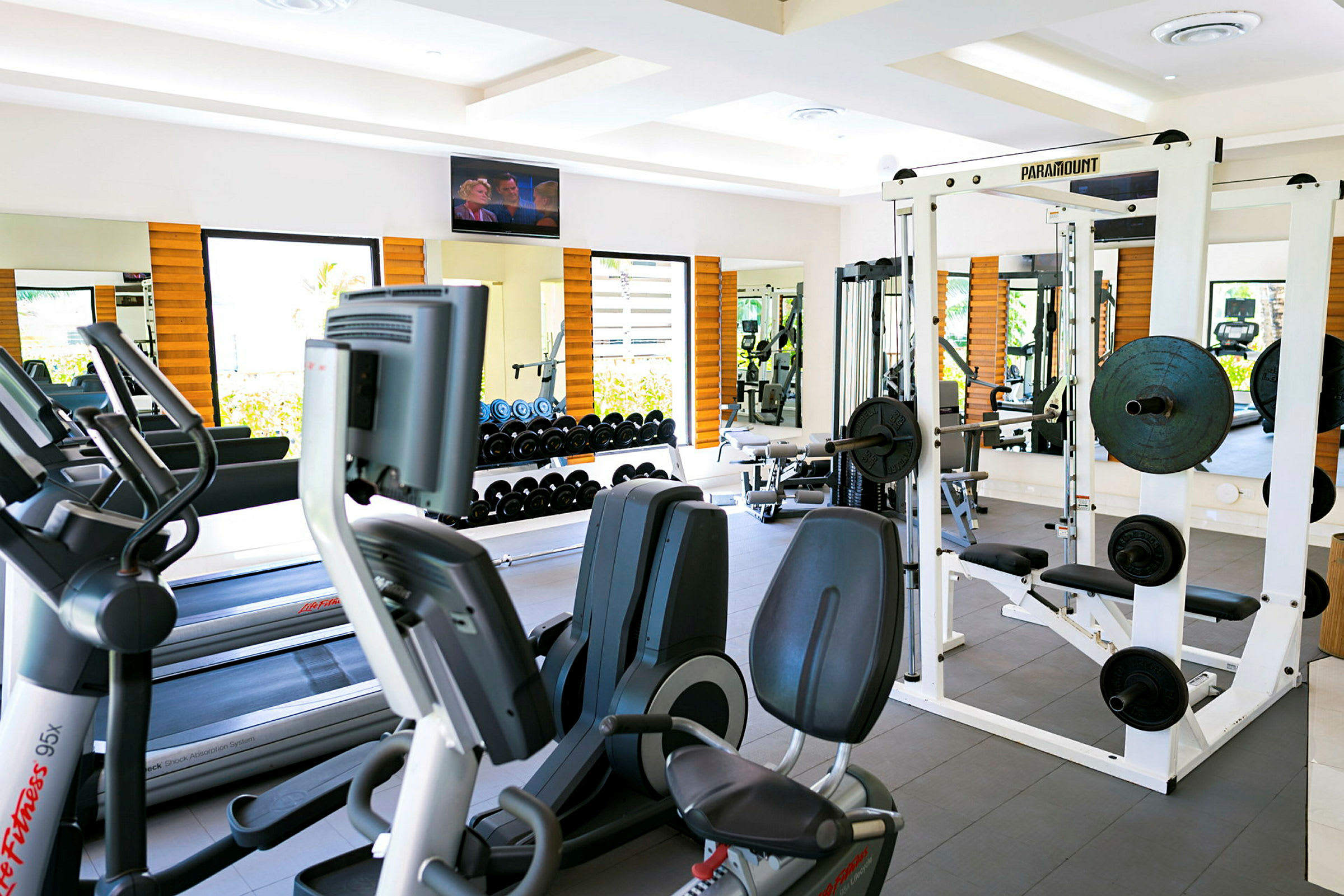 Ett gym med träningsmaskiner, fria vikter och speglar. (AI-genererad text)