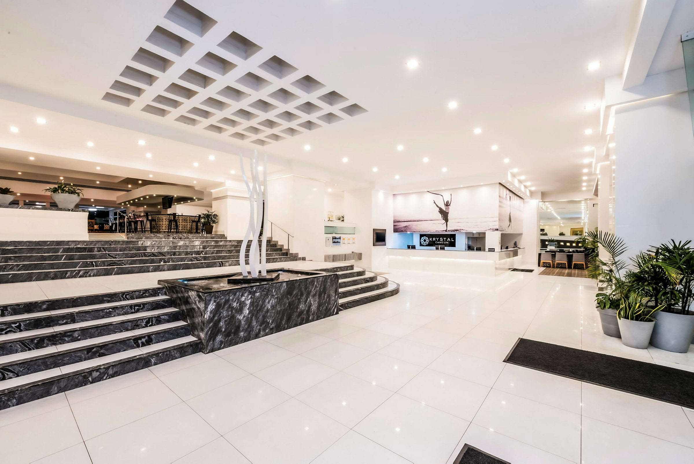 Hotellets lobby med en reception, marmorgolv och växter. (AI-genererad text)