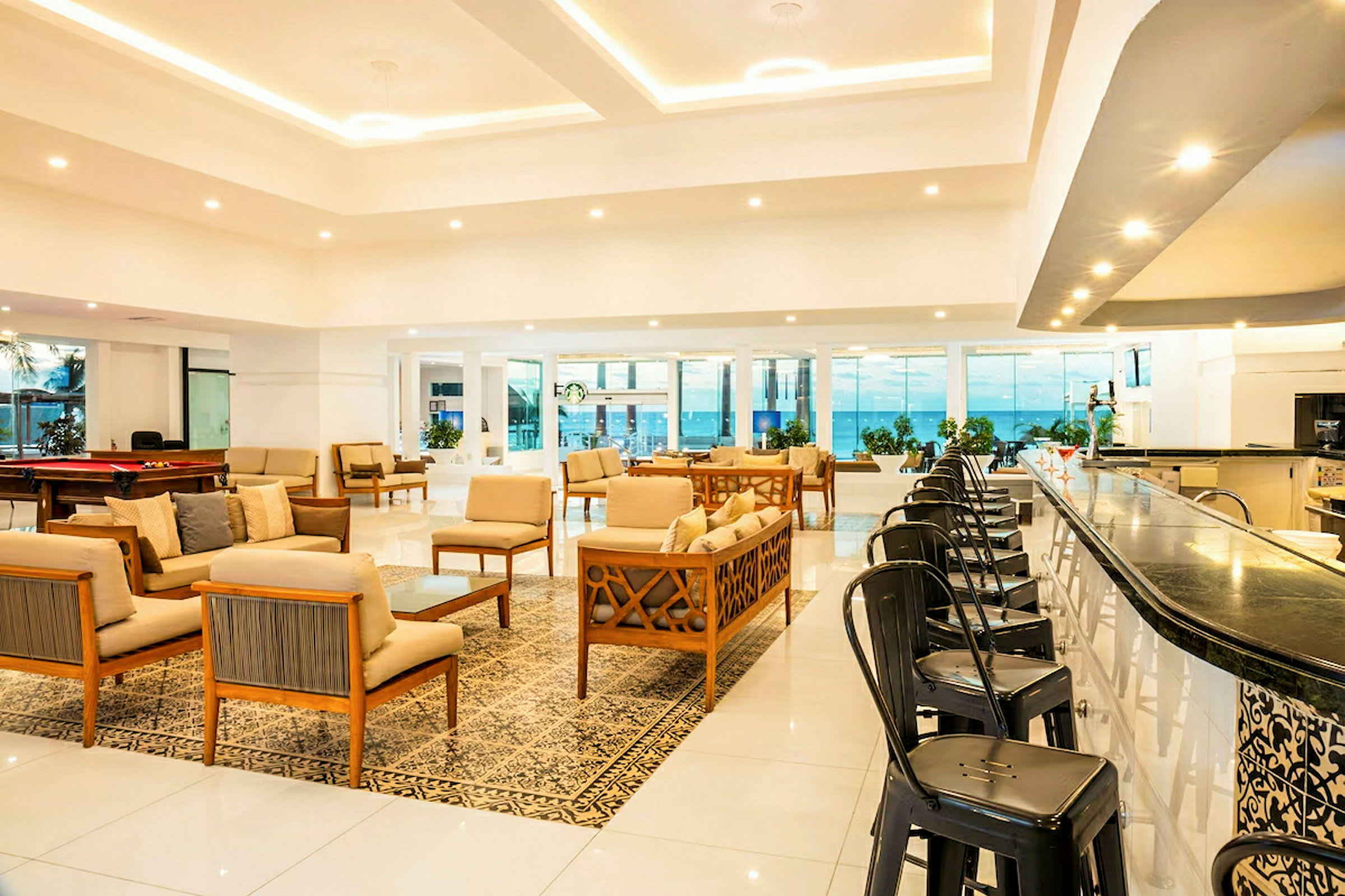 Ett modernt hotell lobbymiljö med sittgrupper och en bar. (AI-genererad text)
