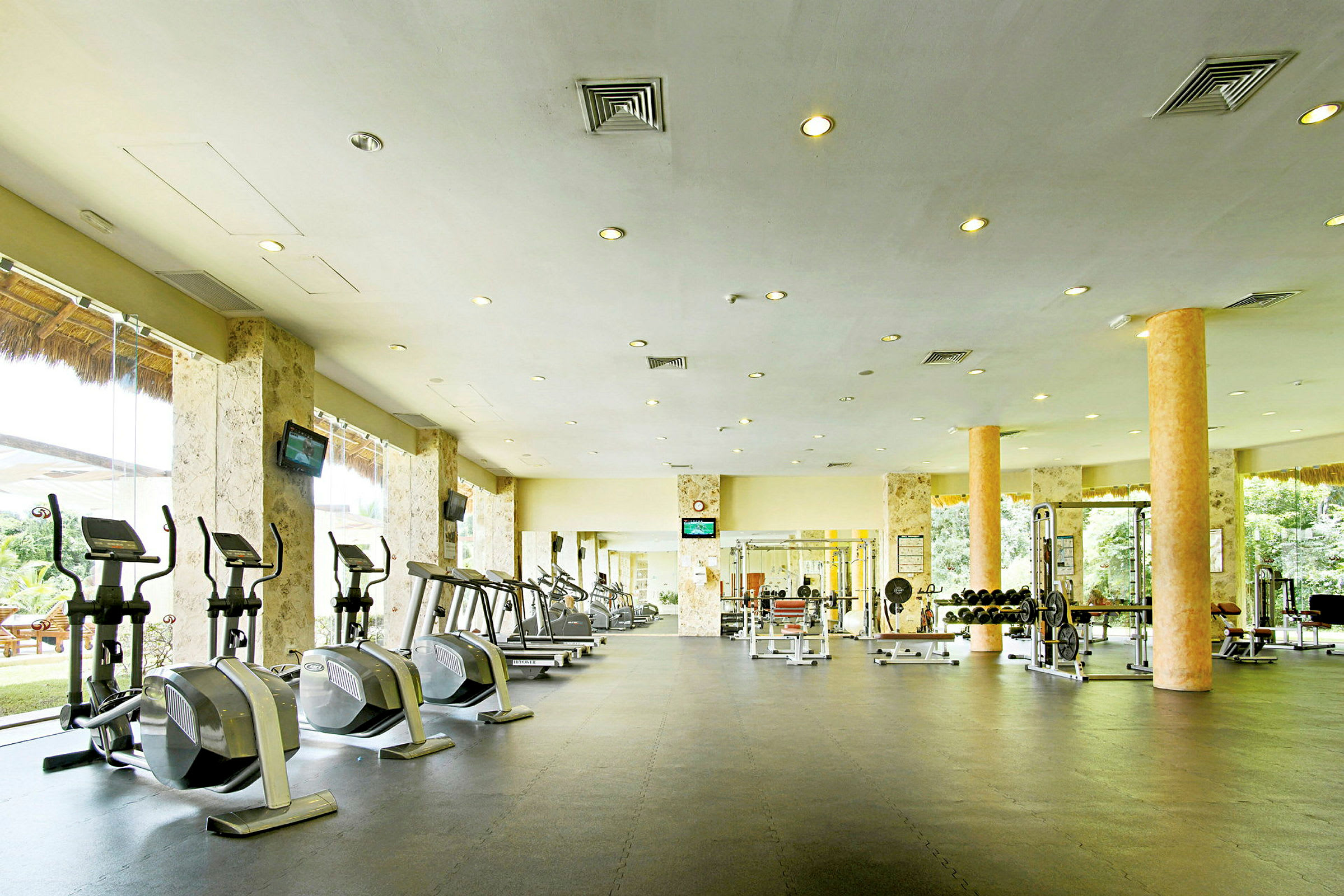 Inomhus gym med träningsmaskiner, vikter och speglar. (AI-genererad text)