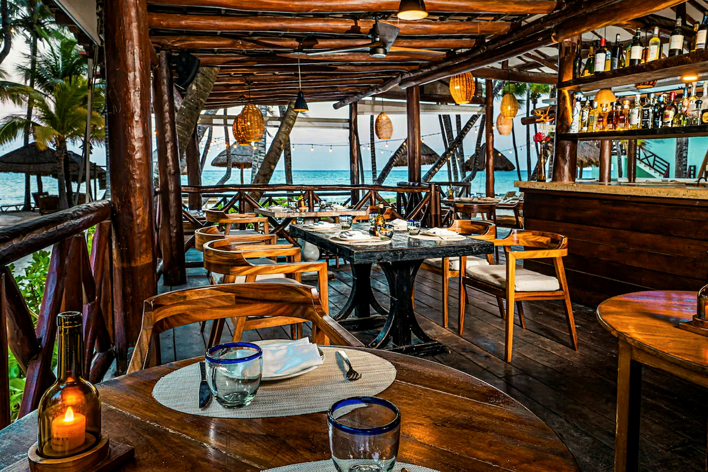 En restaurang med trämöbler och havsutsikt. (AI-genererad text)