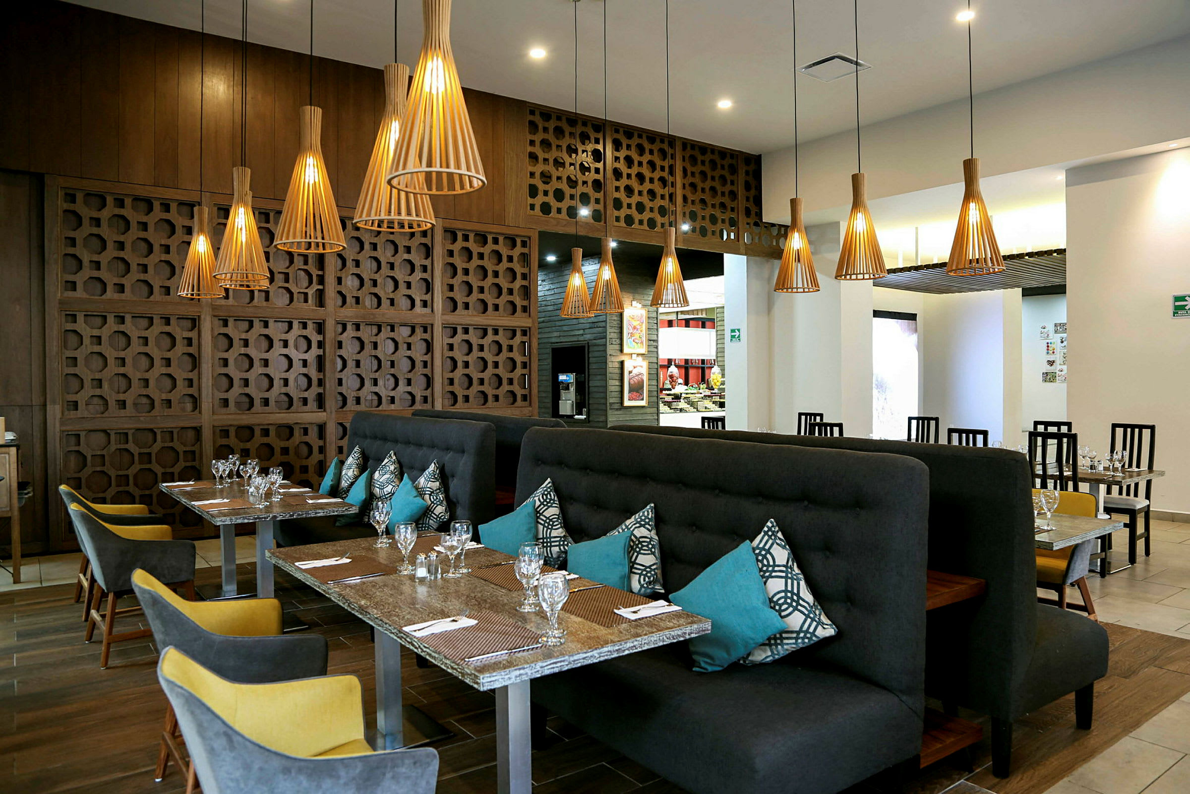 En restaurang med eleganta bord och stolar, snyggt belysning och moderna dekorativa inslag. (AI-genererad text)