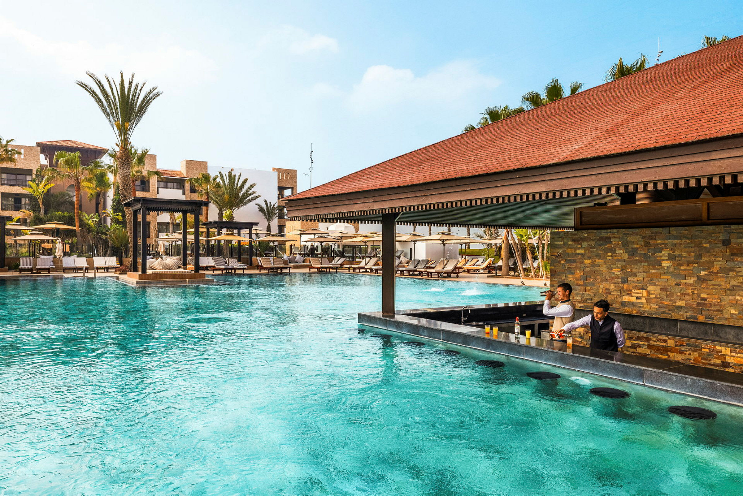 Pool med bar och solstolar i ett semesterkomplex. (AI-genererad text)