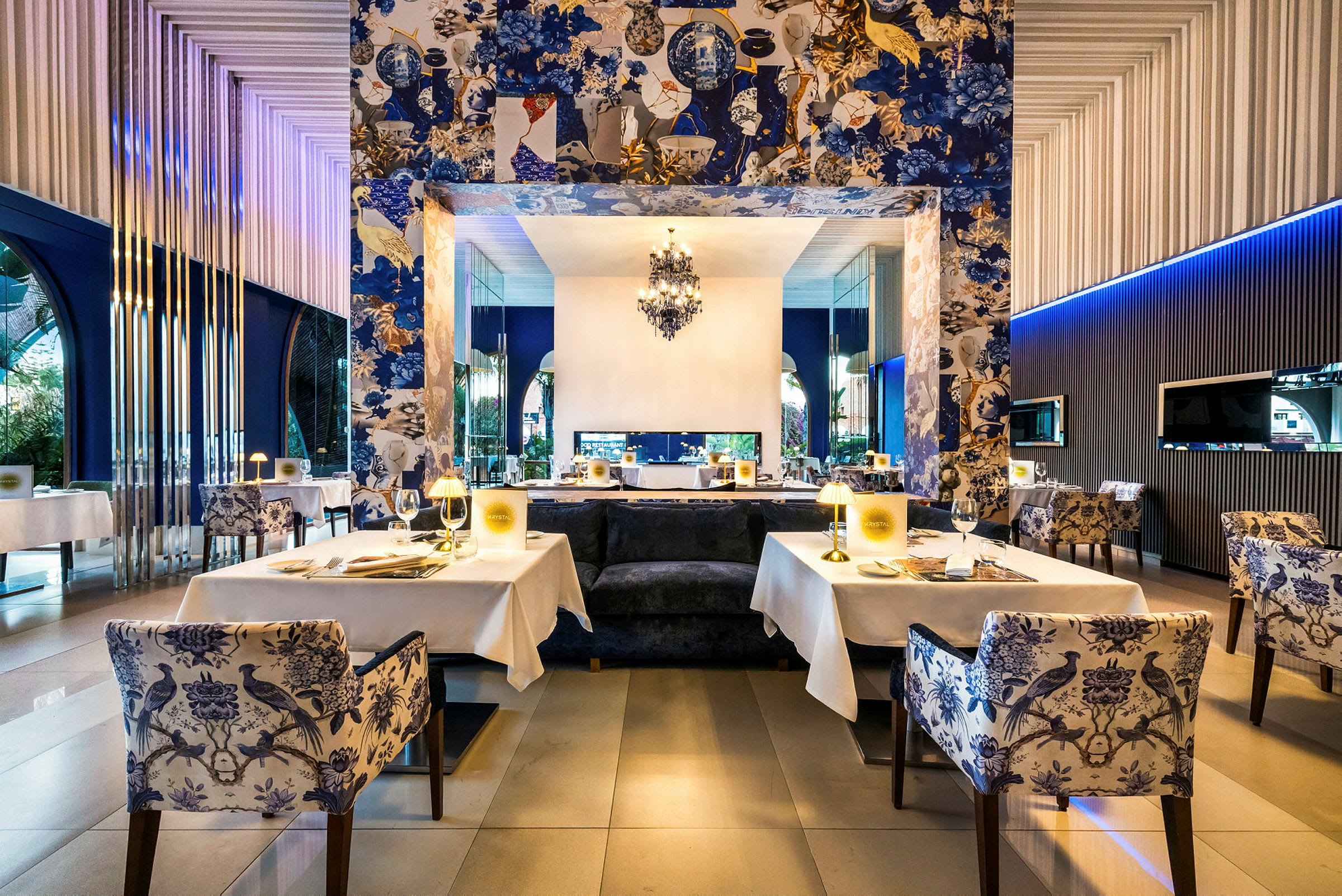En elegant restaurang med dukade bord, dekorativa blå tapeter och belysning. (AI-genererad text)