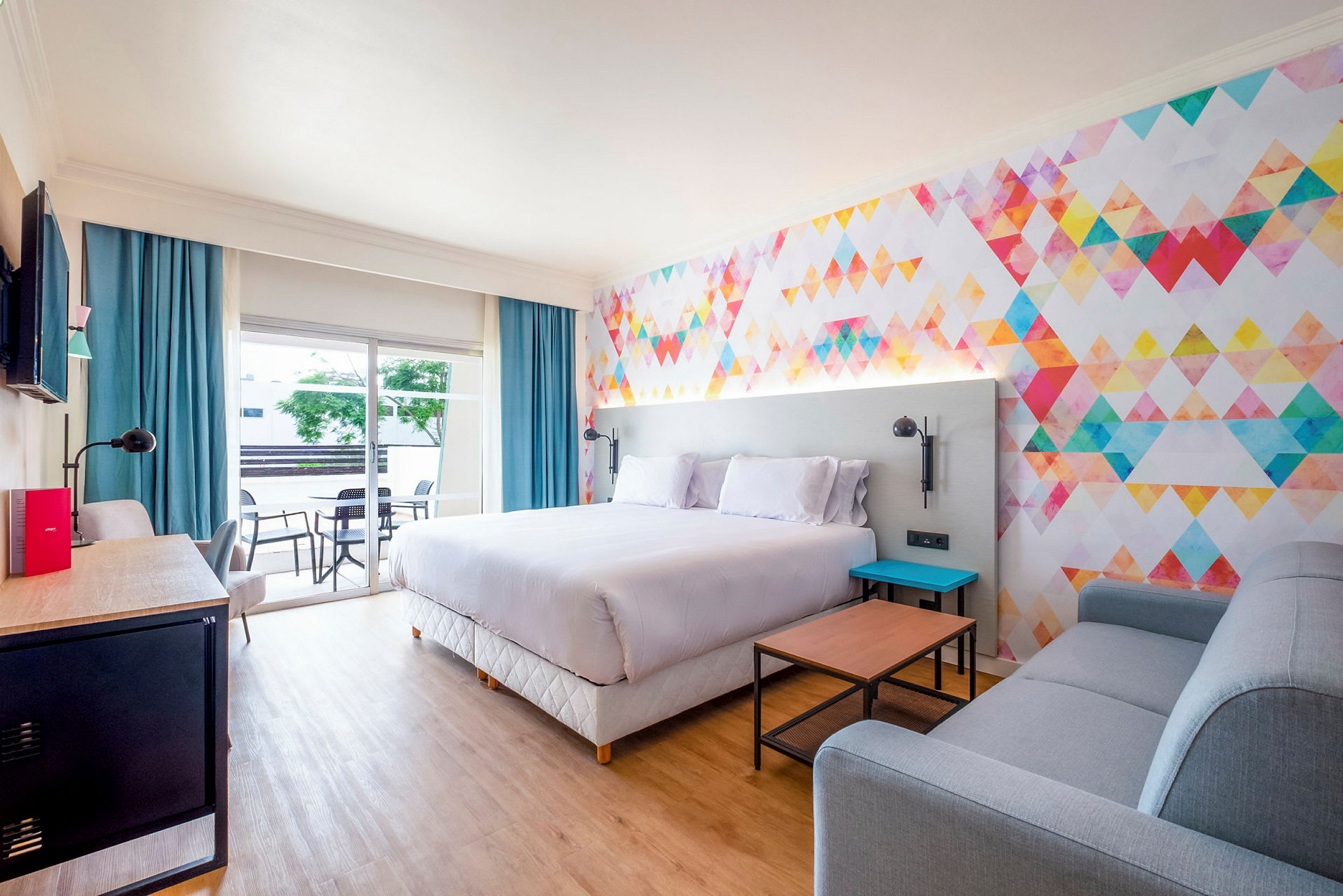 Modern hotellrum med färgglad väggdesign och bekväma möbler. (AI-genererad text)