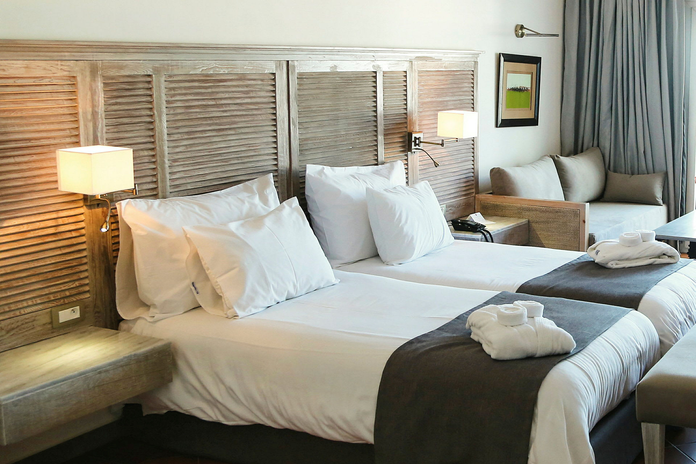 Hotellrum med två sängar, en soffa och inredningsdetaljer. (AI-genererad text)