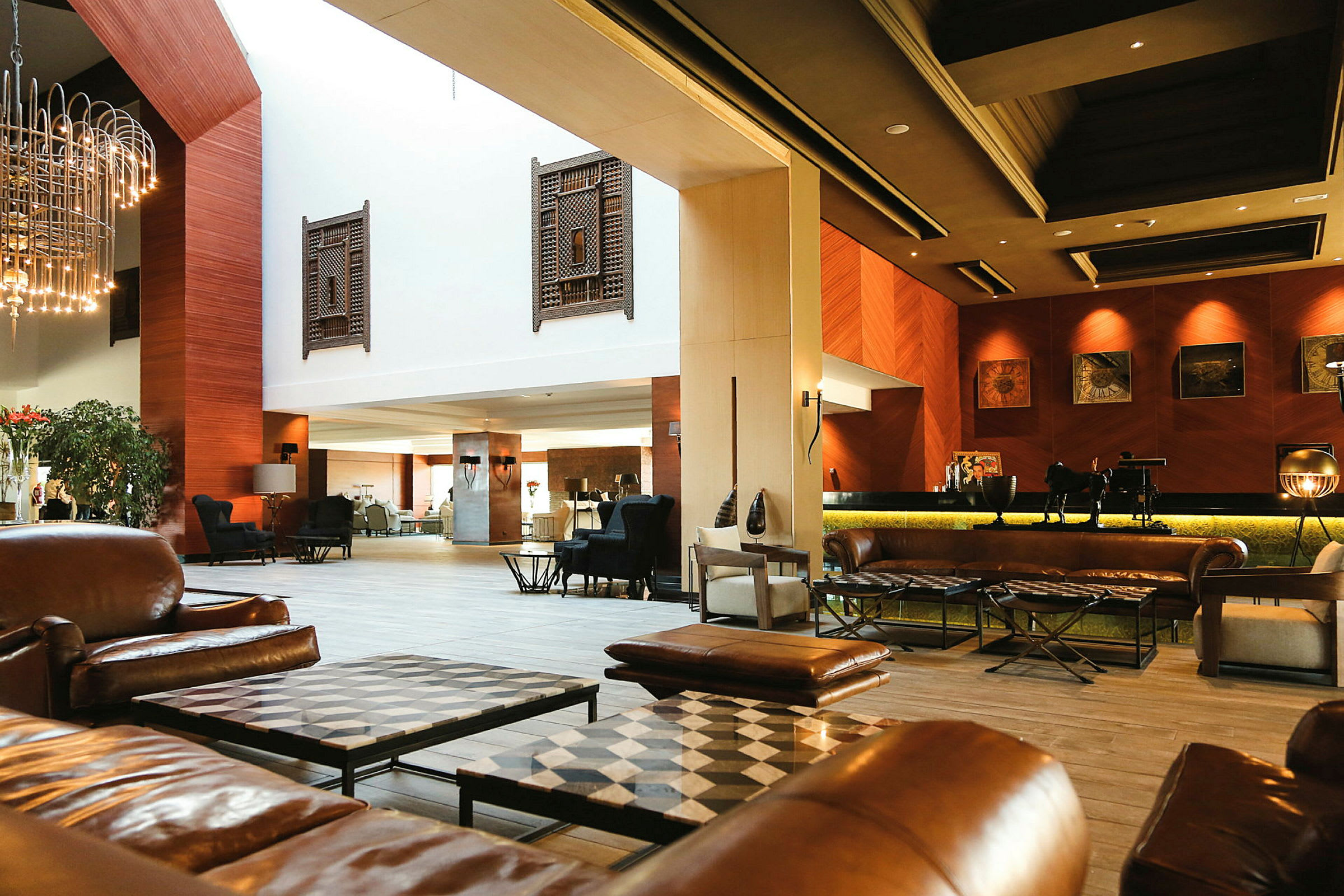 Ett hotellobby med lädermöbler och inredning i varma färger. (AI-genererad text)