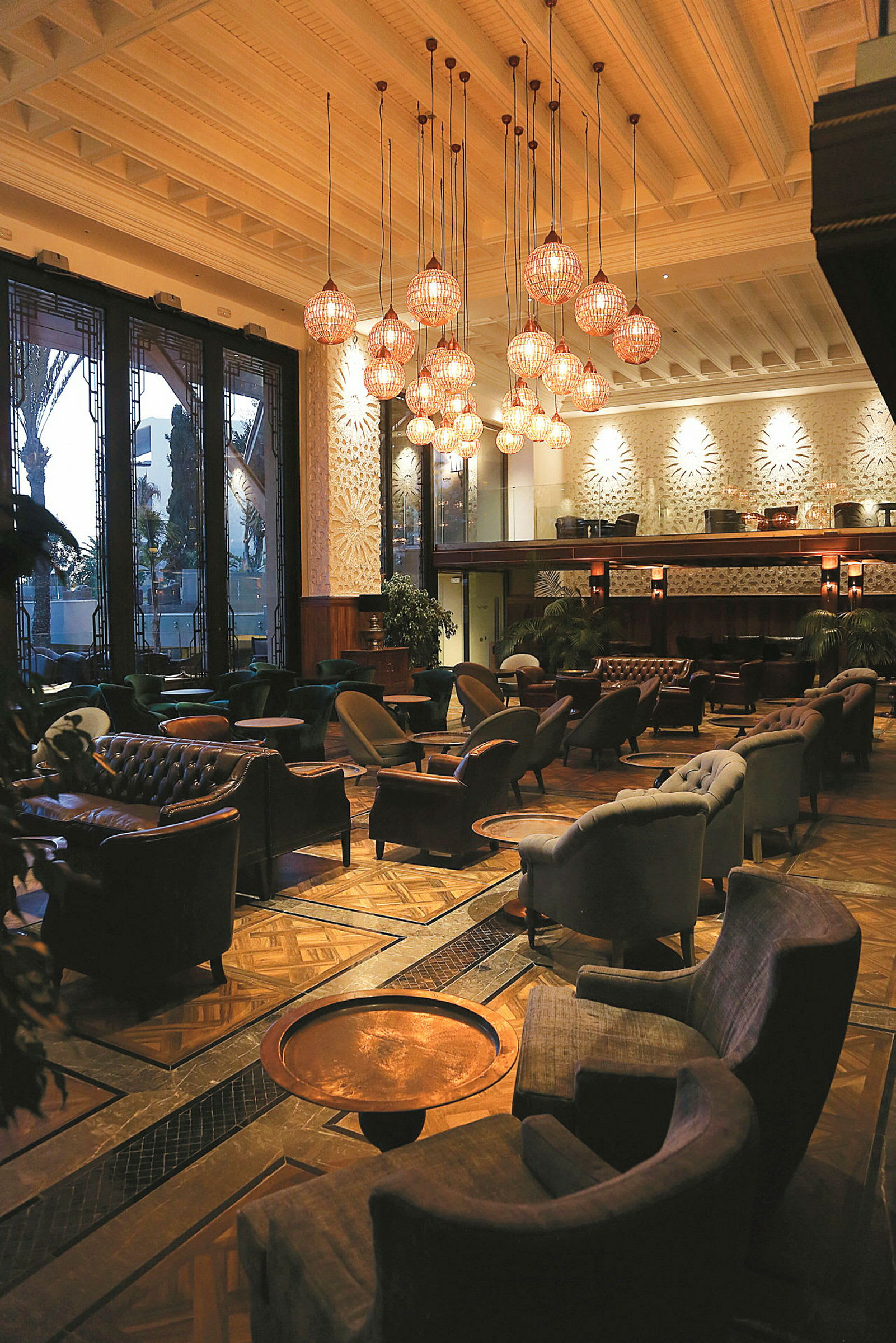 Interiör av en elegant lounge med bekväma sittmöbler och belysning från taklampor. (AI-genererad text)