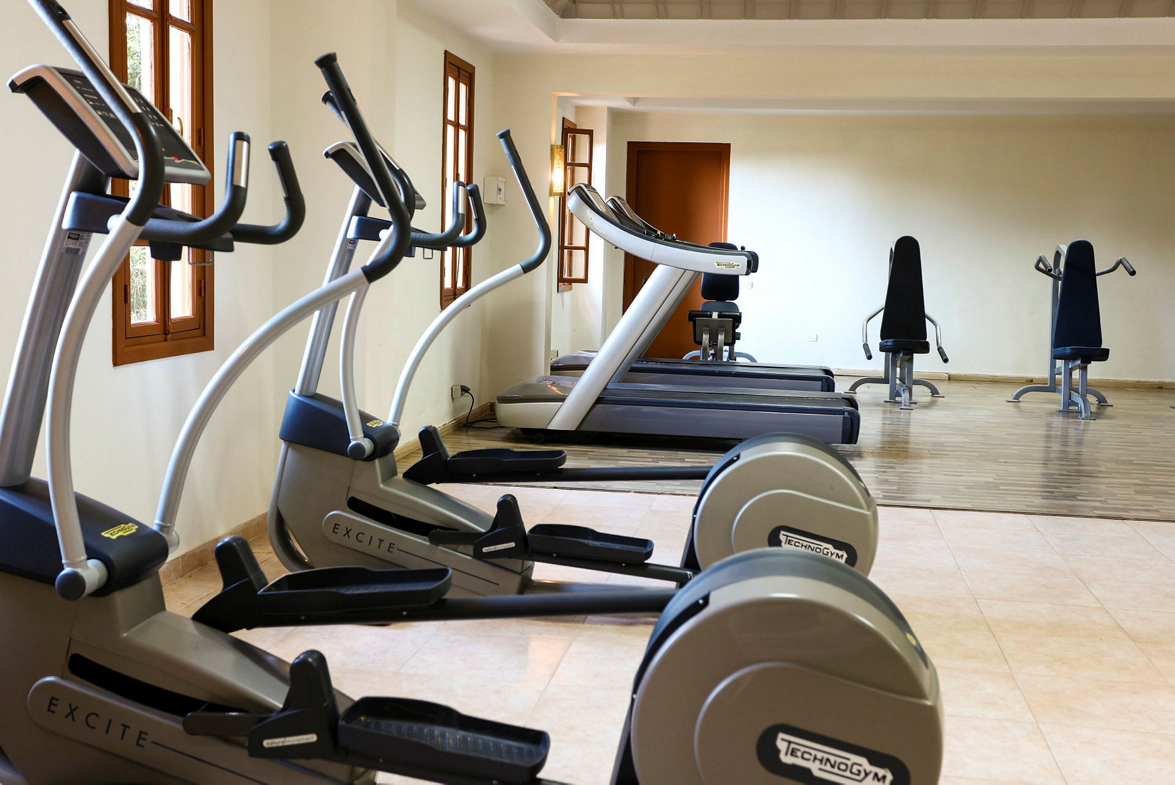 Bild av ett gym med träningsmaskiner inklusive löpband och träningscyklar. (AI-genererad text)