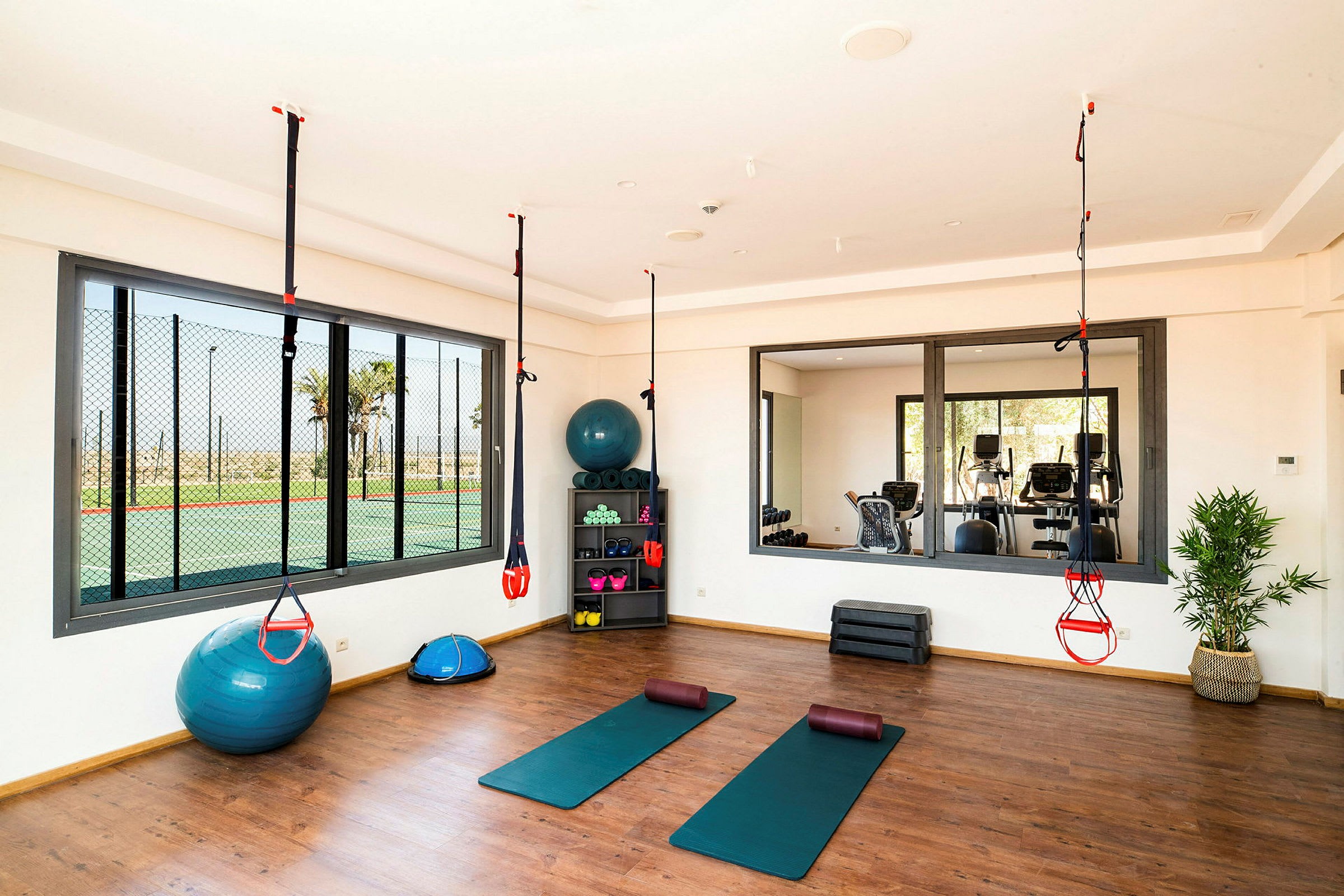 Gym med träningsmattor, styrketräningsutrustning och suspensionsträning. (AI-genererad text)