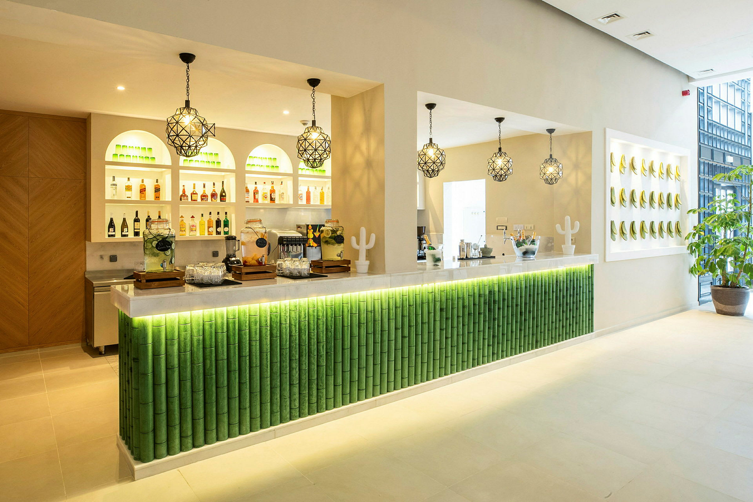 En modern bar med upplyst grön bambuinspirerad design och drycker på hyllor. (AI-genererad text)