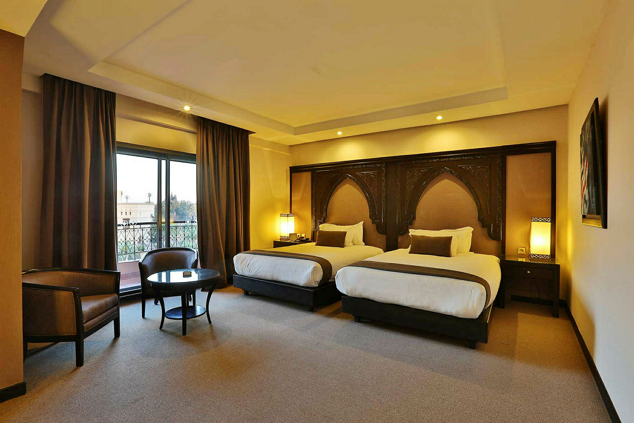 Ett hotellrum med två enkelsängar, sittgrupp och stort fönster. (AI-genererad text)