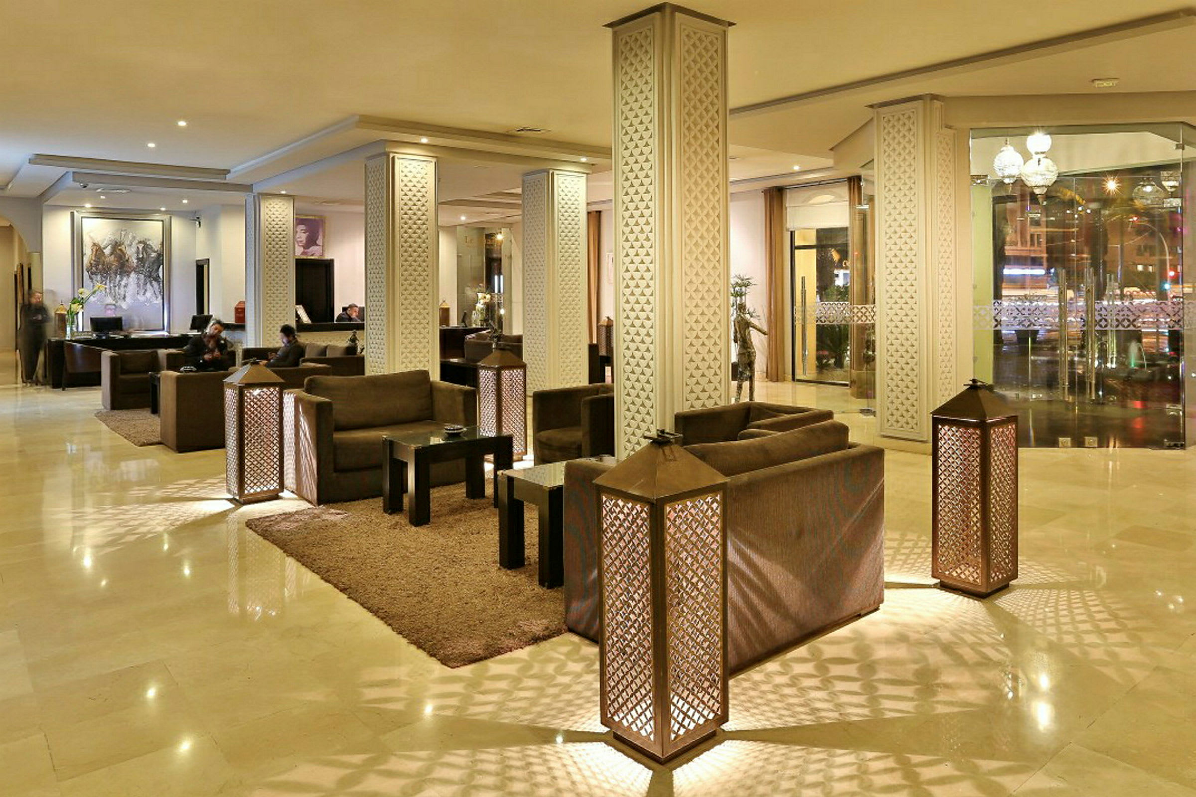 Ett elegant hotellobbyutrymme med soffgrupper och dekorativa pelare. (AI-genererad text)