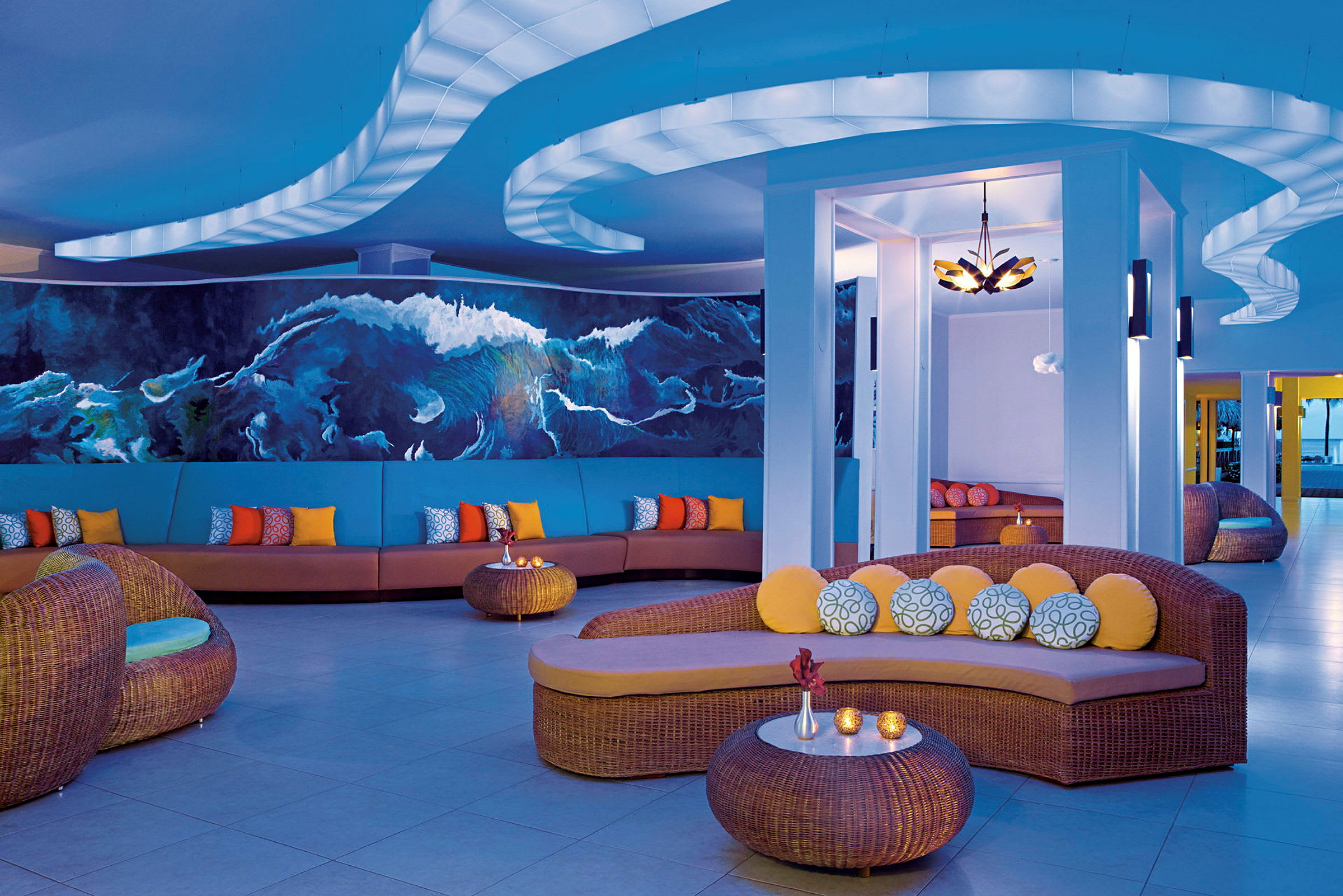 En modern och färgglad lounge med soffor, kuddar och soffbord i ett elegant inrett utrymme. (AI-genererad text)