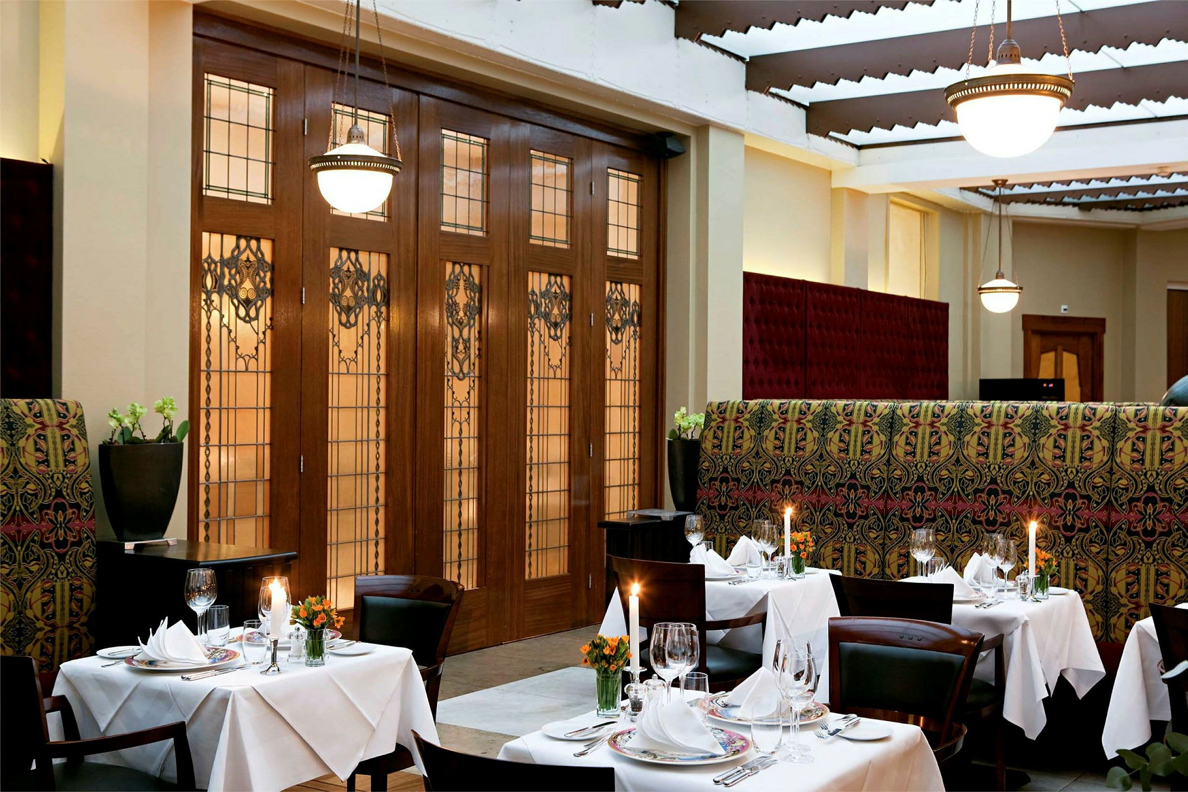 En elegant restaurang med dukade bord, ljuslyktor och dekorativ inredning. (AI-genererad text)