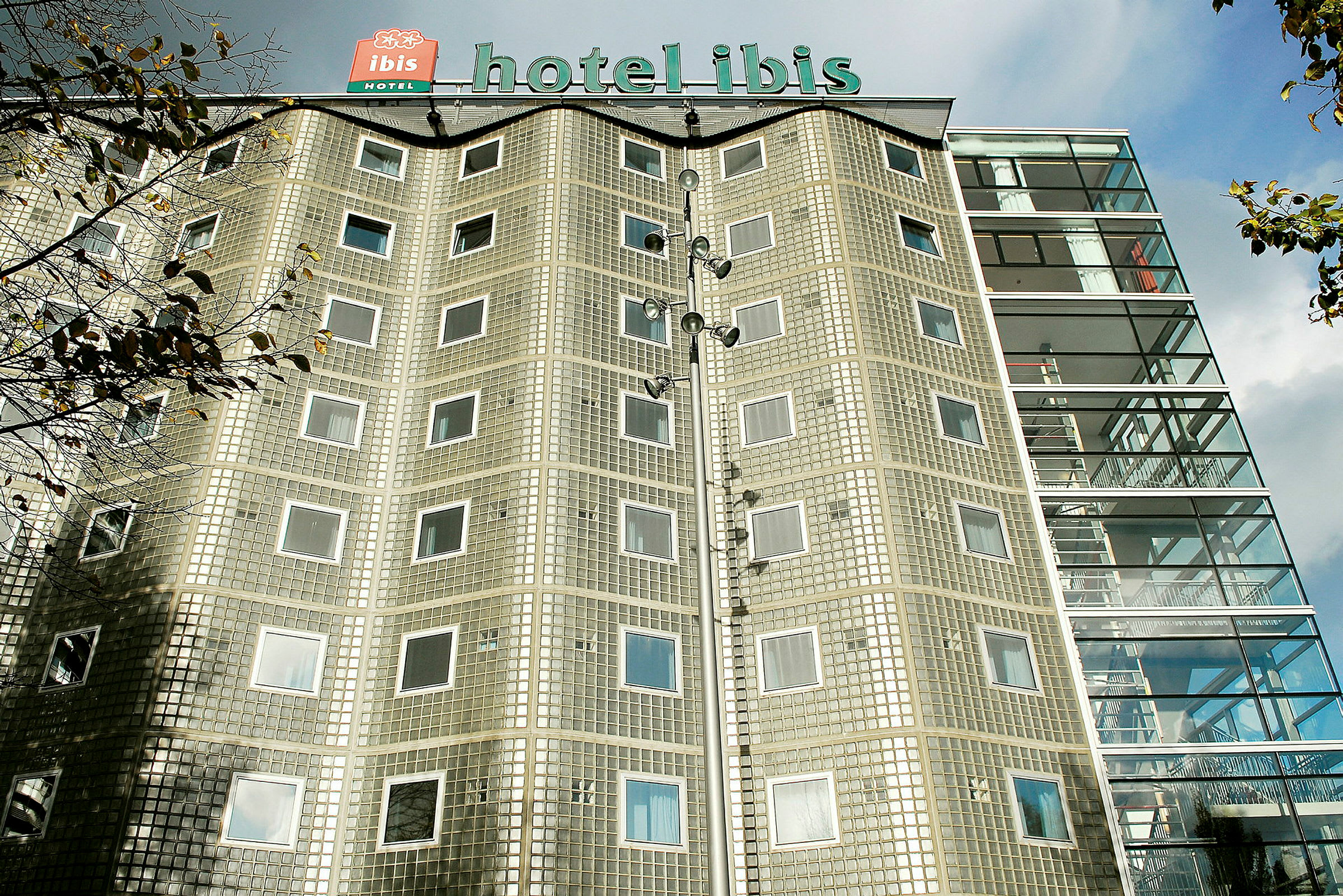Byggnad med hotellets namn på taket och fasad av glasblock samt fönster. (AI-genererad text)
