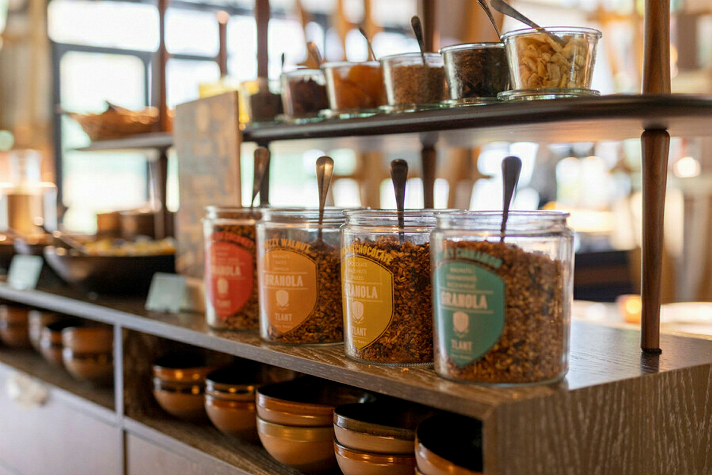 Flera glasburkar med granola på en hylla i närbild. (AI-genererad text)