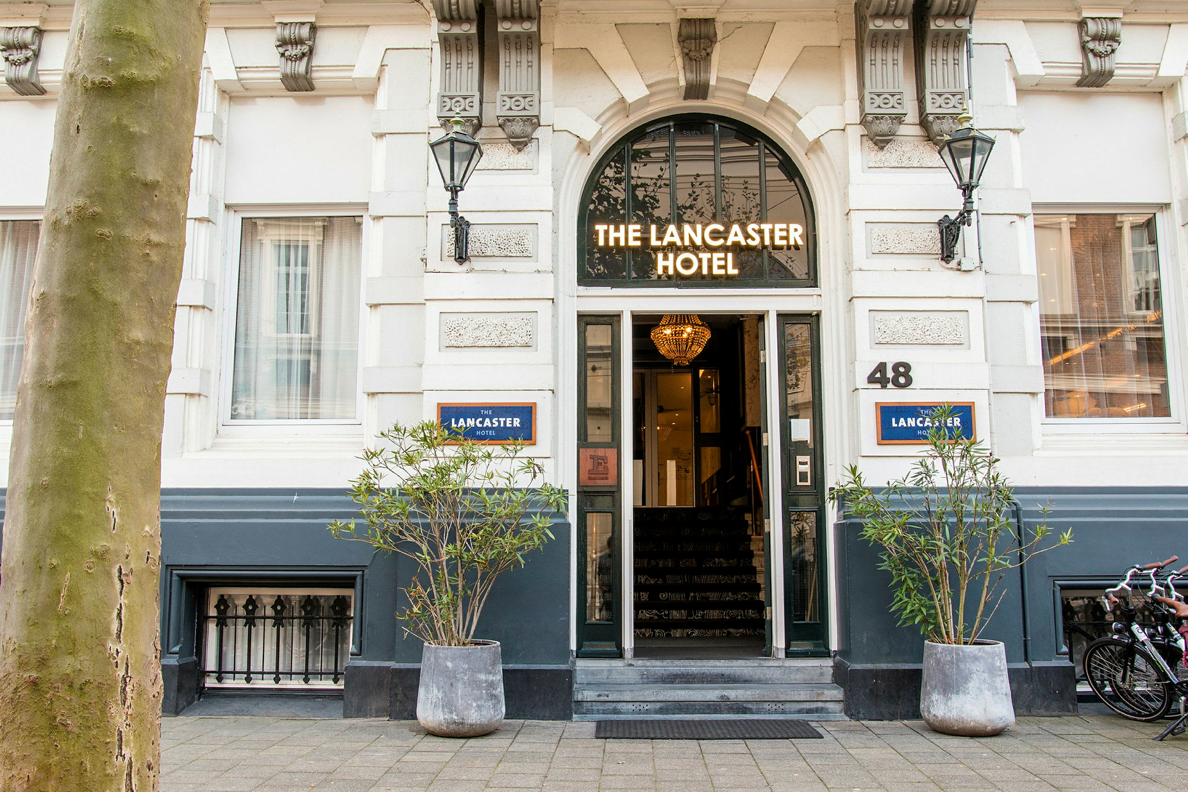 Entré till ett hotell med skylten 'The Lancaster Hotel' ovanför dörren. (AI-genererad text)