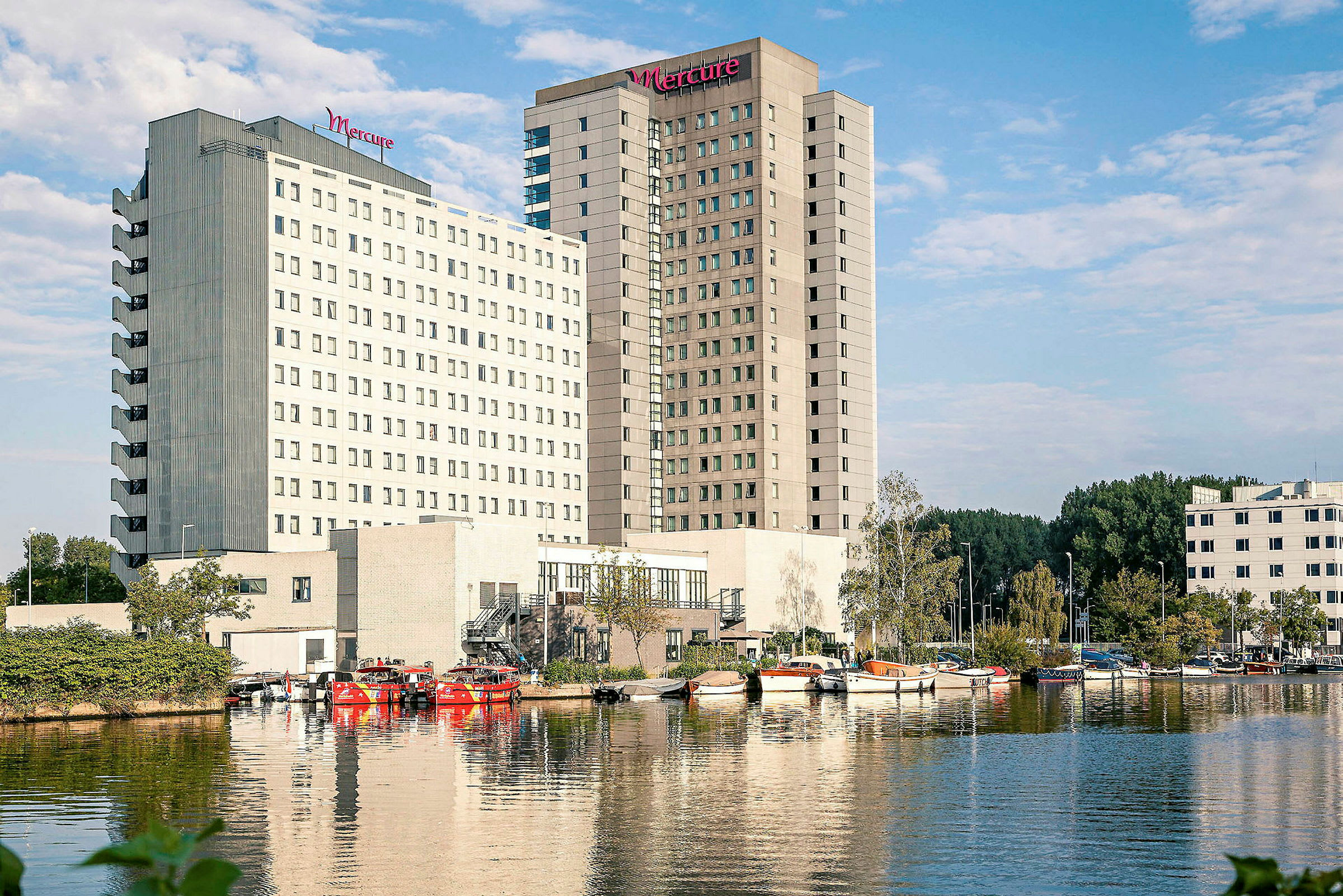 Hotellbyggnader vid vattnet, med båtar i förgrunden. (AI-genererad text)