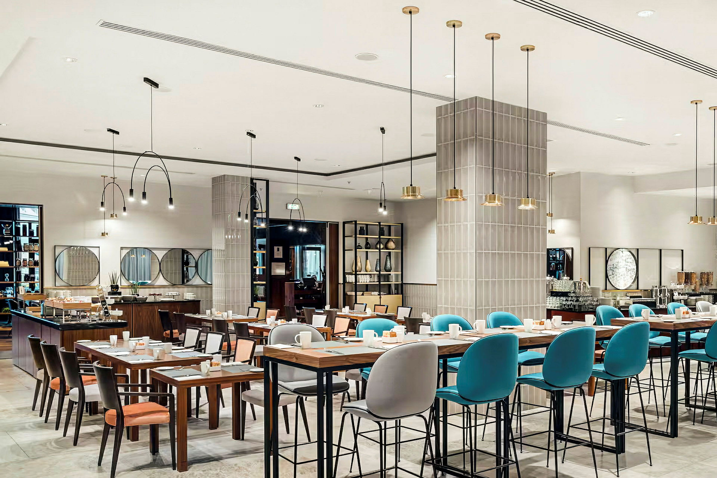 En modern restaurang med dukade bord och stolar, samt taklampor som hänger ned från taket. (AI-genererad text)