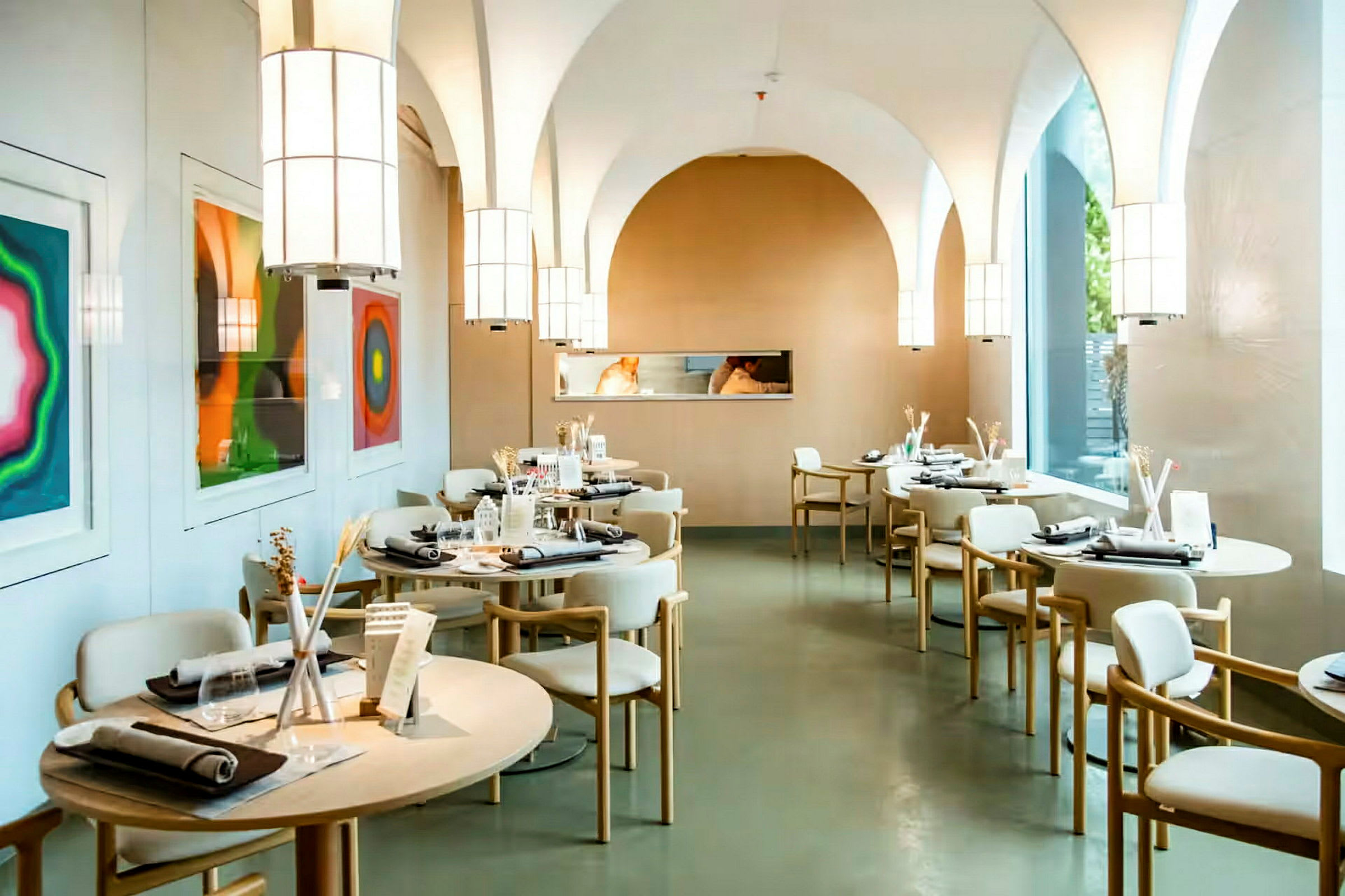 En modern restaurang med uppdukade bord och konstverk på väggen. (AI-genererad text)
