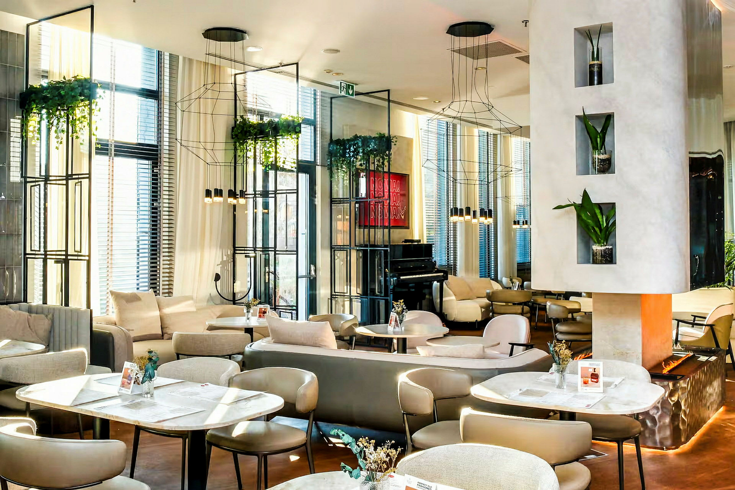 En modern lounge med eleganta möbler, hängande växter och en piano i bakgrunden. (AI-genererad text)