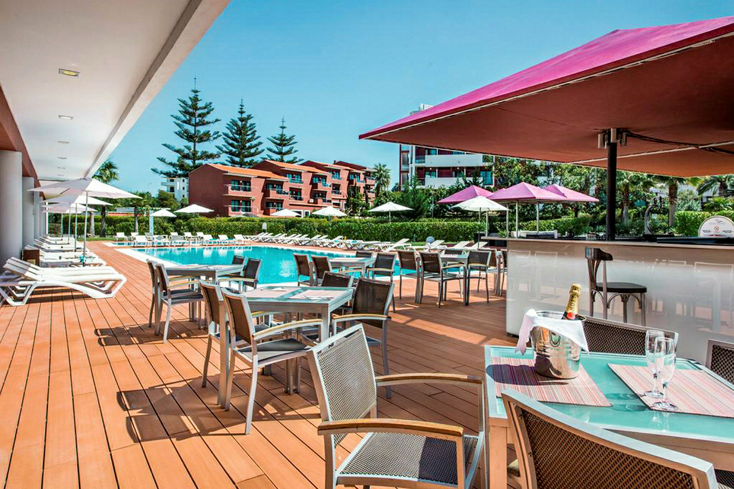Utomhusområde med pool, solstolar och ett matserveringsområde. (AI-genererad text)
