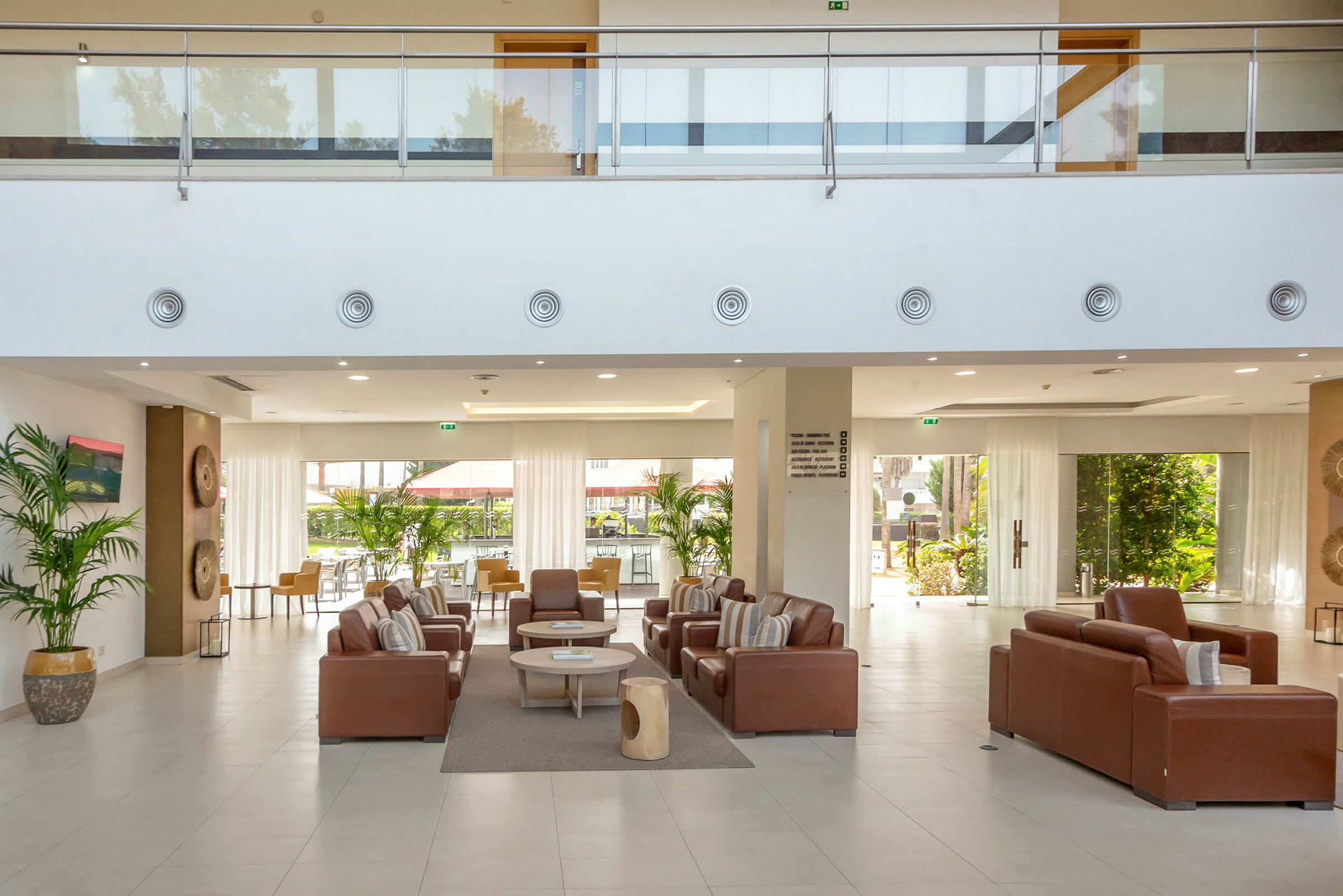 Hotellobby med sittgrupper och stora fönster. (AI-genererad text)