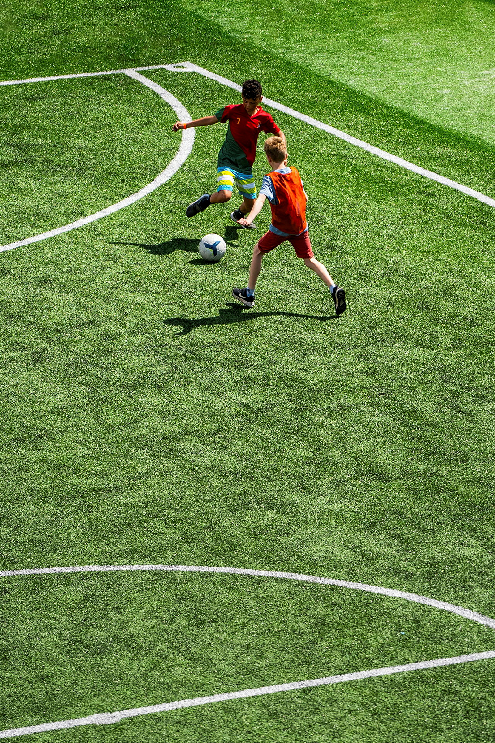 Två personer spelar fotboll på en gräsplan. (AI-genererad text)