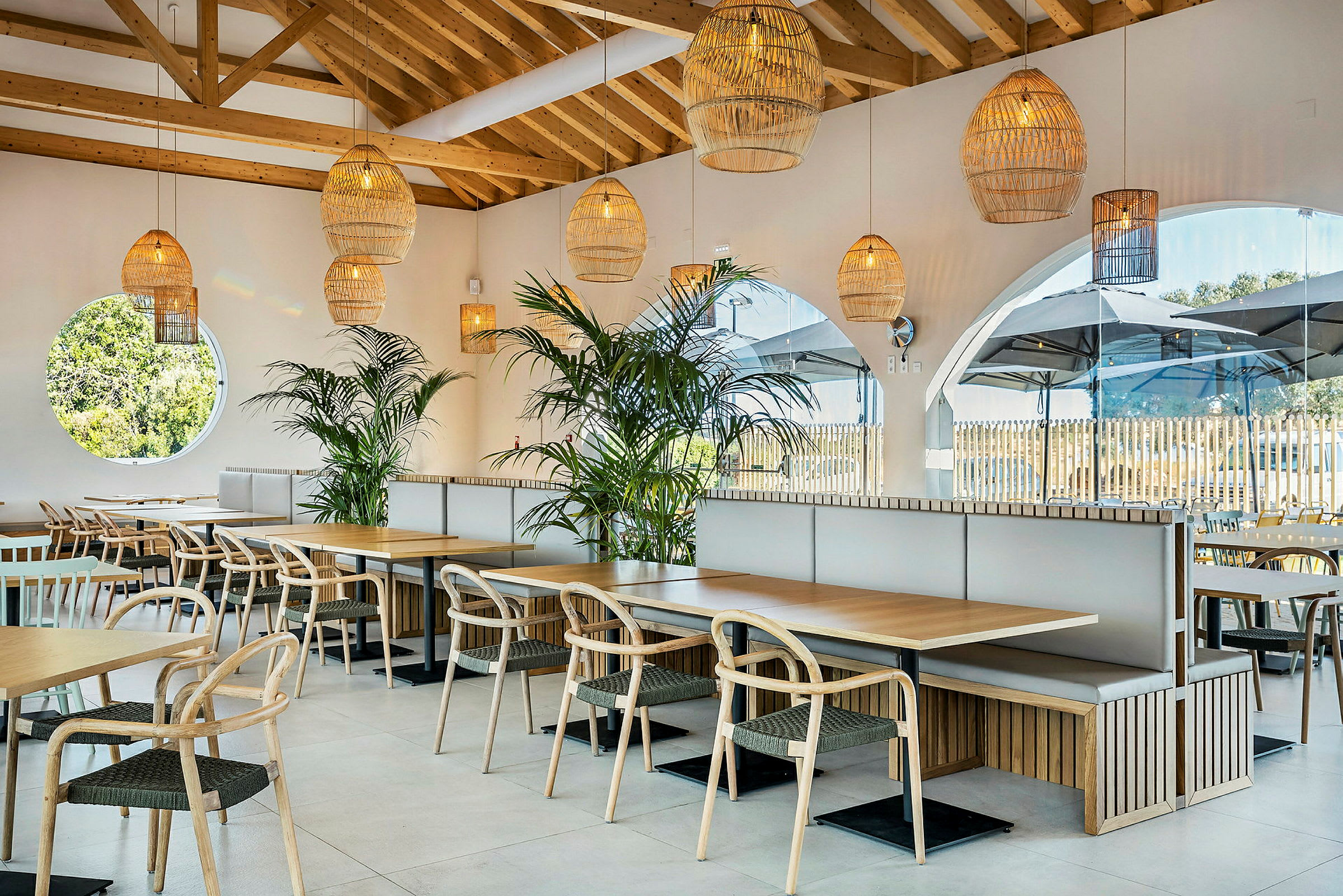 En modern restaurang med träbord, stolar och gröna växter. (AI-genererad text)
