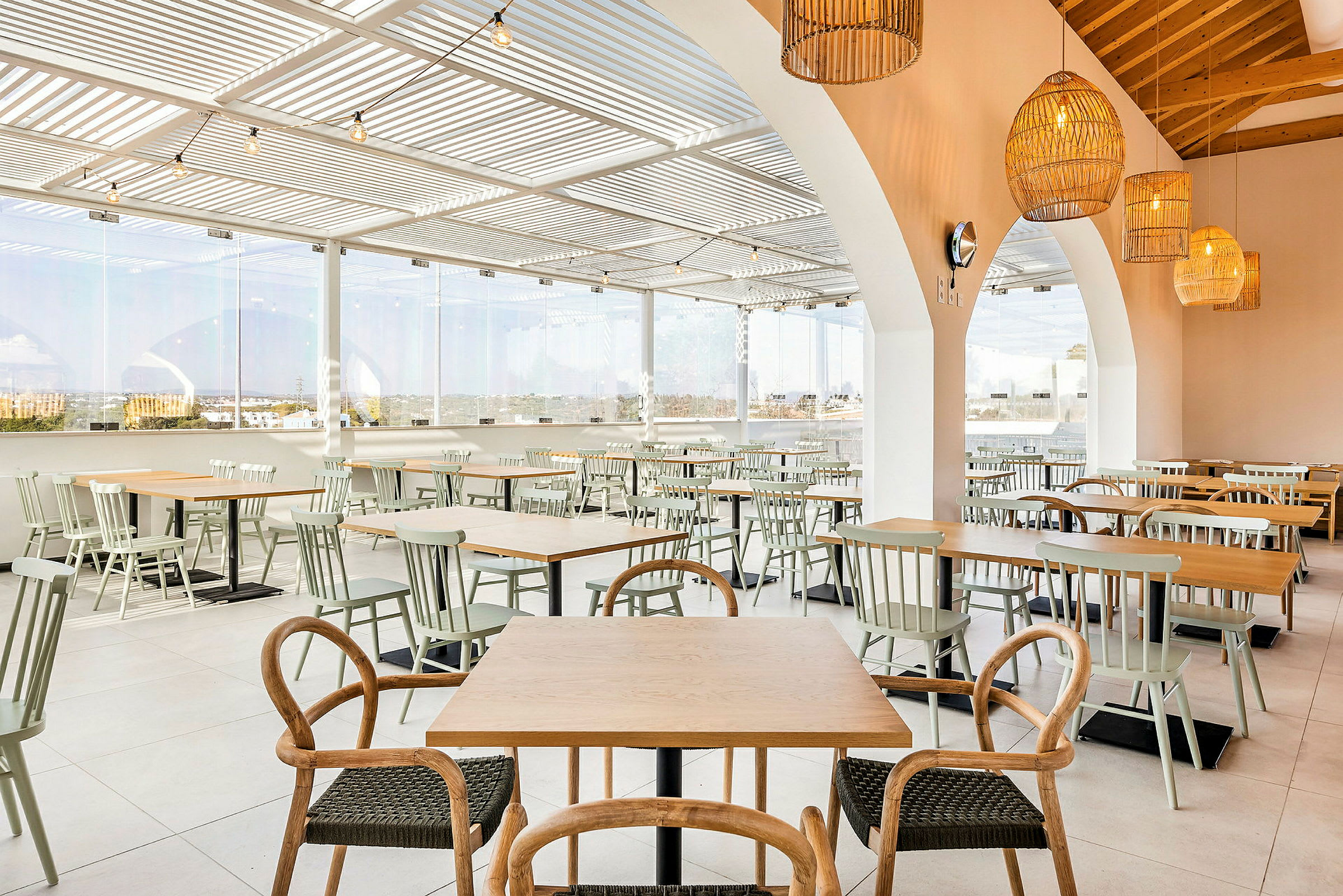 Bild på en restaurang med bord och stolar i öppet och ljust utrymme. (AI-genererad text)