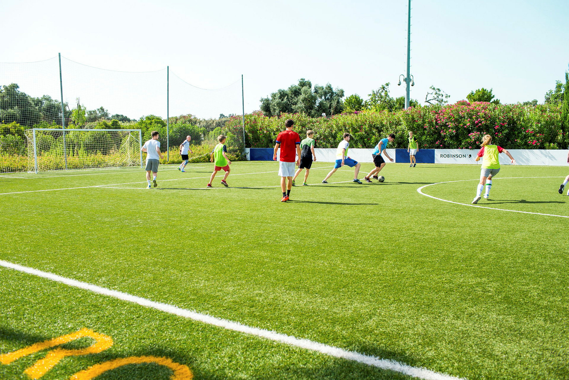 En grupp människor spelar fotboll på en gräsplan. (AI-genererad text)