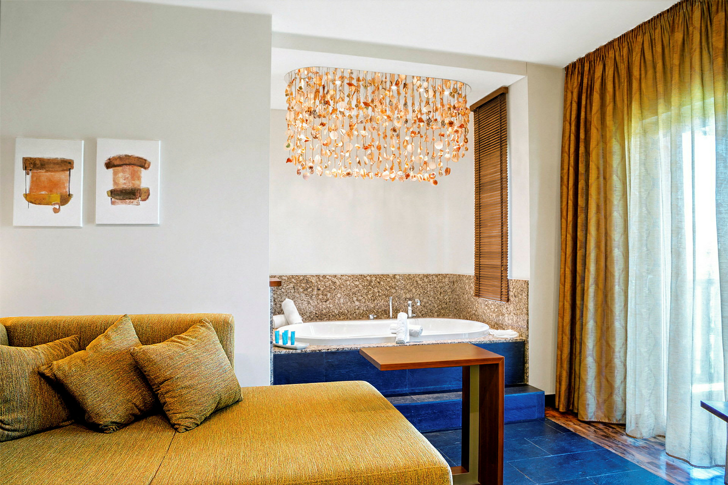Interiör av ett hotellrum med en sittgrupp, konst på väggen, en jacuzzi och en dekorativ taklampa. (AI-genererad text)