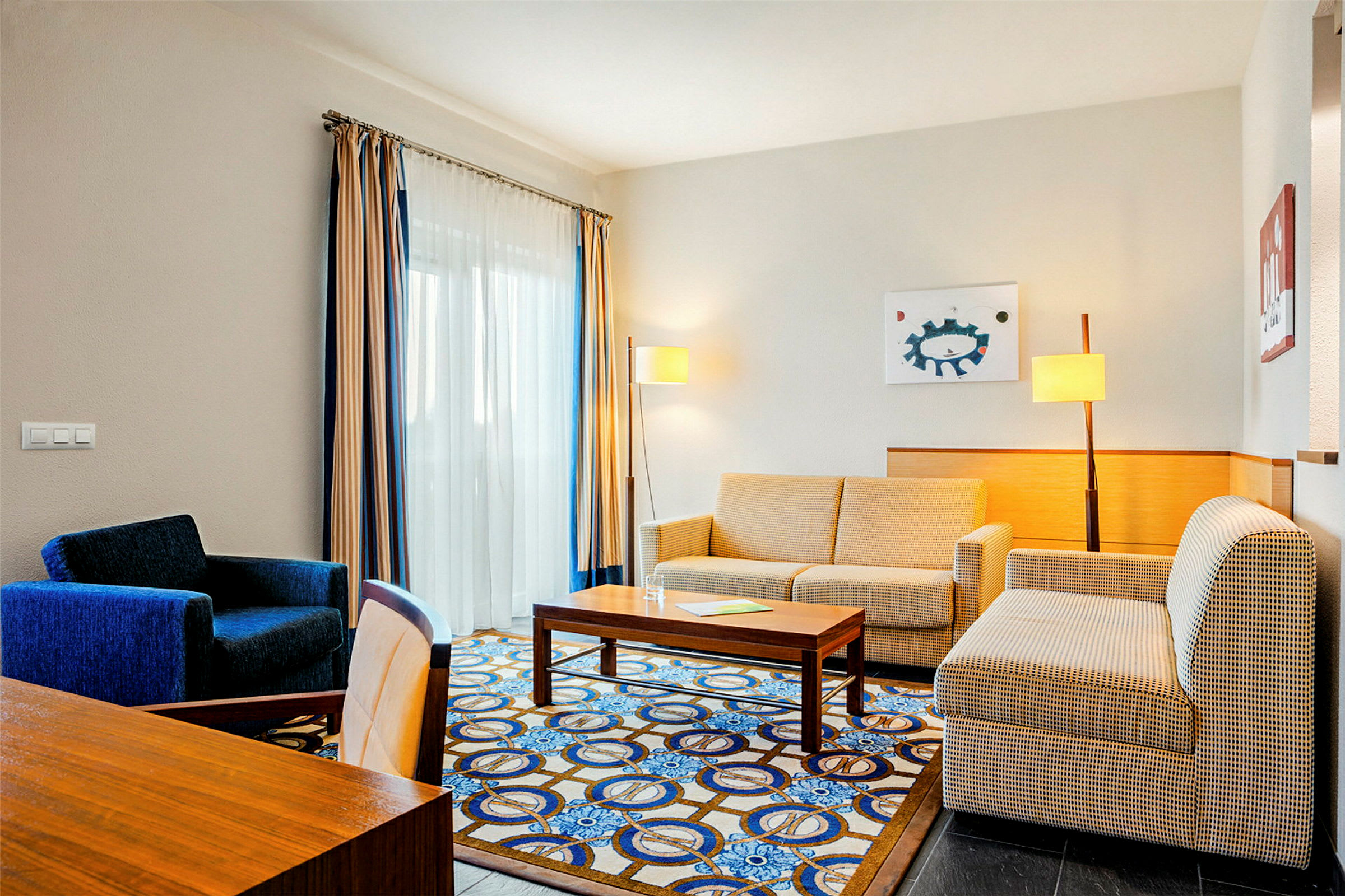 Ett hotellrum med soffa, fåtölj och bord. (AI-genererad text)